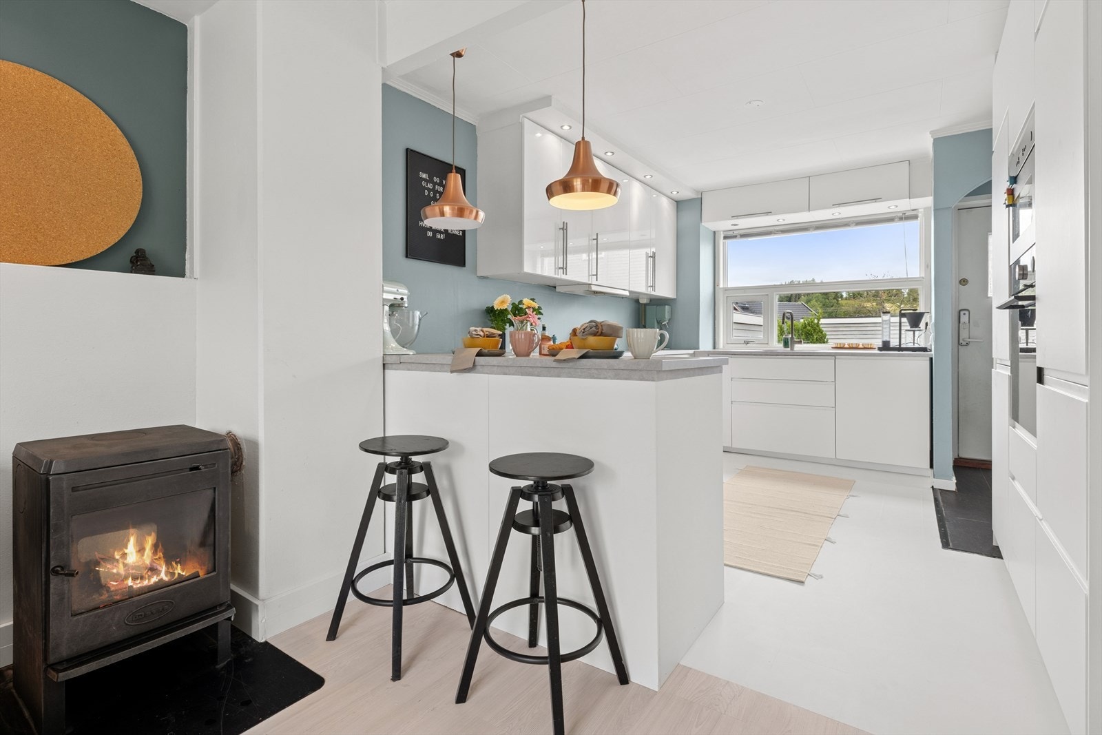 Kjøkken med praktisk kjøkkenøy. Det er ildsted i stue/ kjøkken som varmer godt på kalde dager. Galleribilde