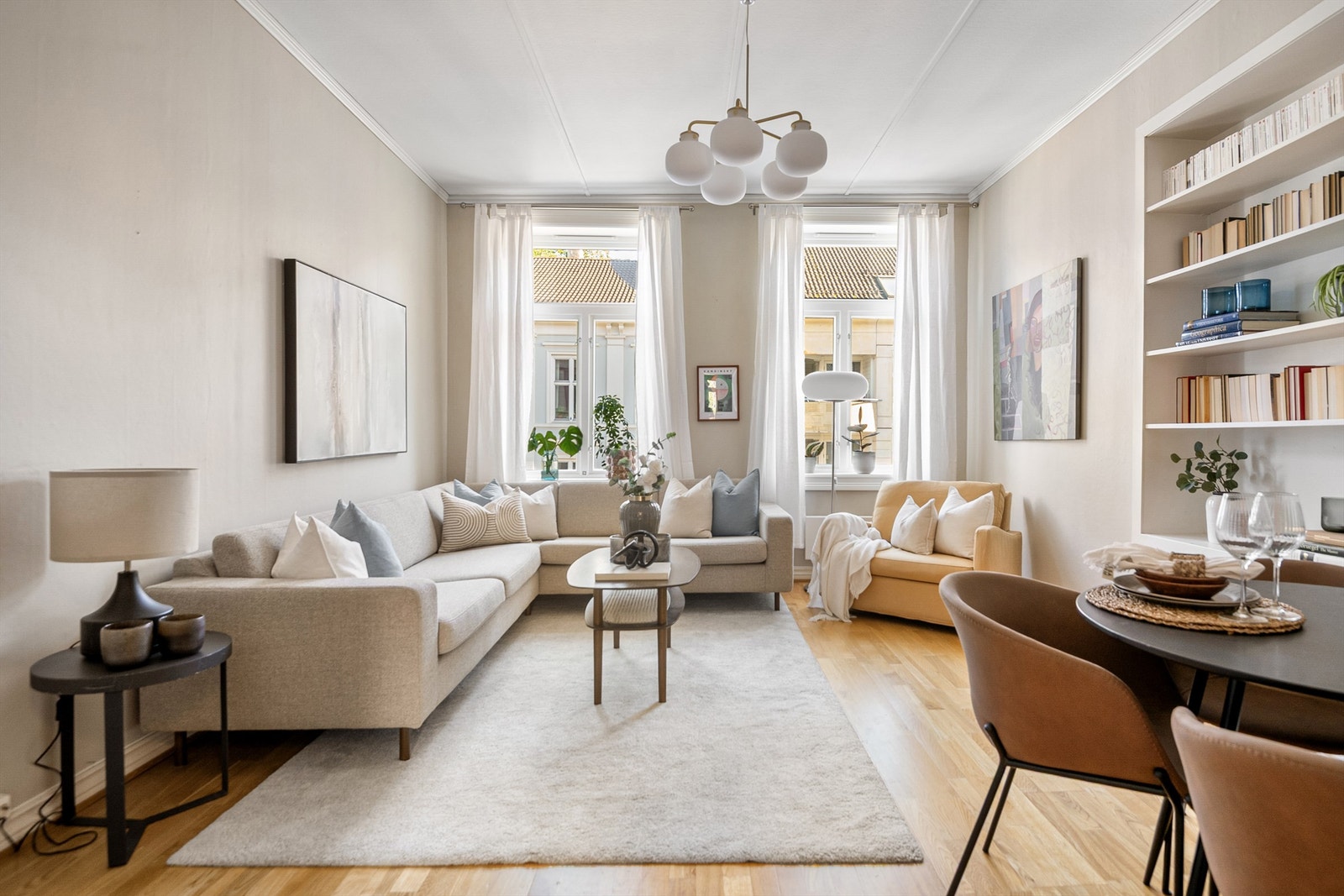 Romslig og åpen stue med peis og store vinduer med dype karmer, som gir rikelig med naturlig belysning. Galleribilde