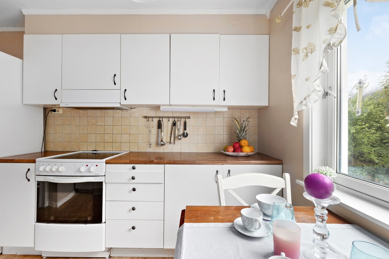 Det er opplegg for frittstående hvitevarer. Flislagt vegg mellom over- og underskap Galleribilde