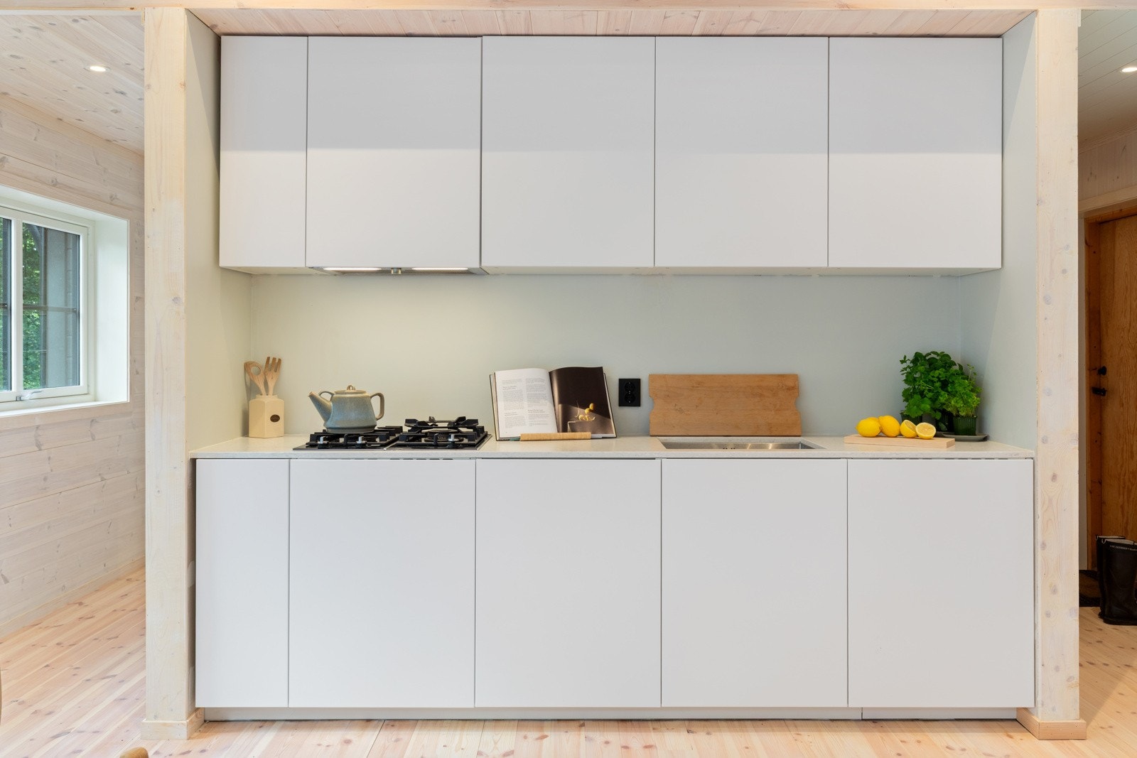 Lyst og pent IKEA-kjøkken med gladde fronter og laminert benkeplate. Galleribilde