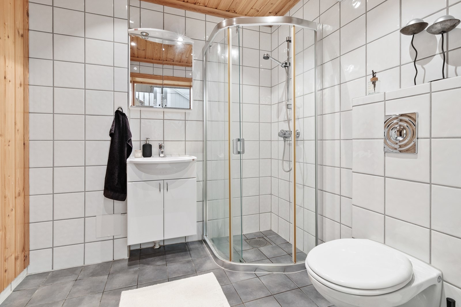 Helfliset baderom med dusjhjørne, servant og toalett. Galleribilde