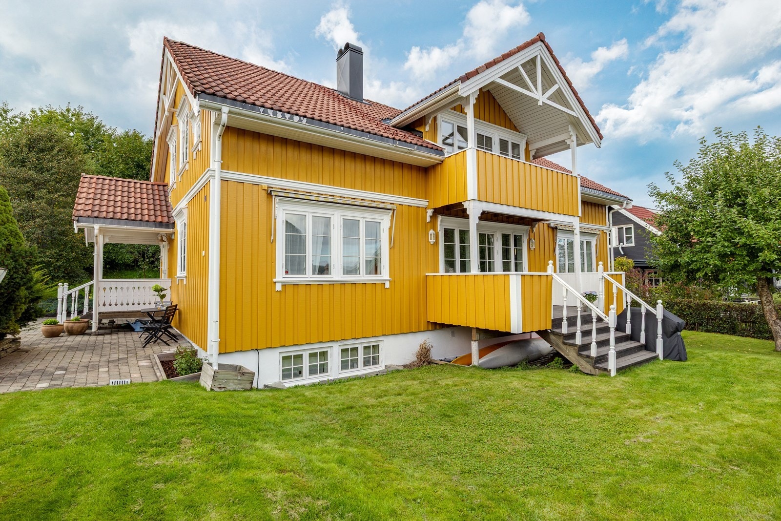 En skjermet og fin uteplass med hekk rundt tomten. Boltreplass for lek på gresset foran terrassen. Galleribilde