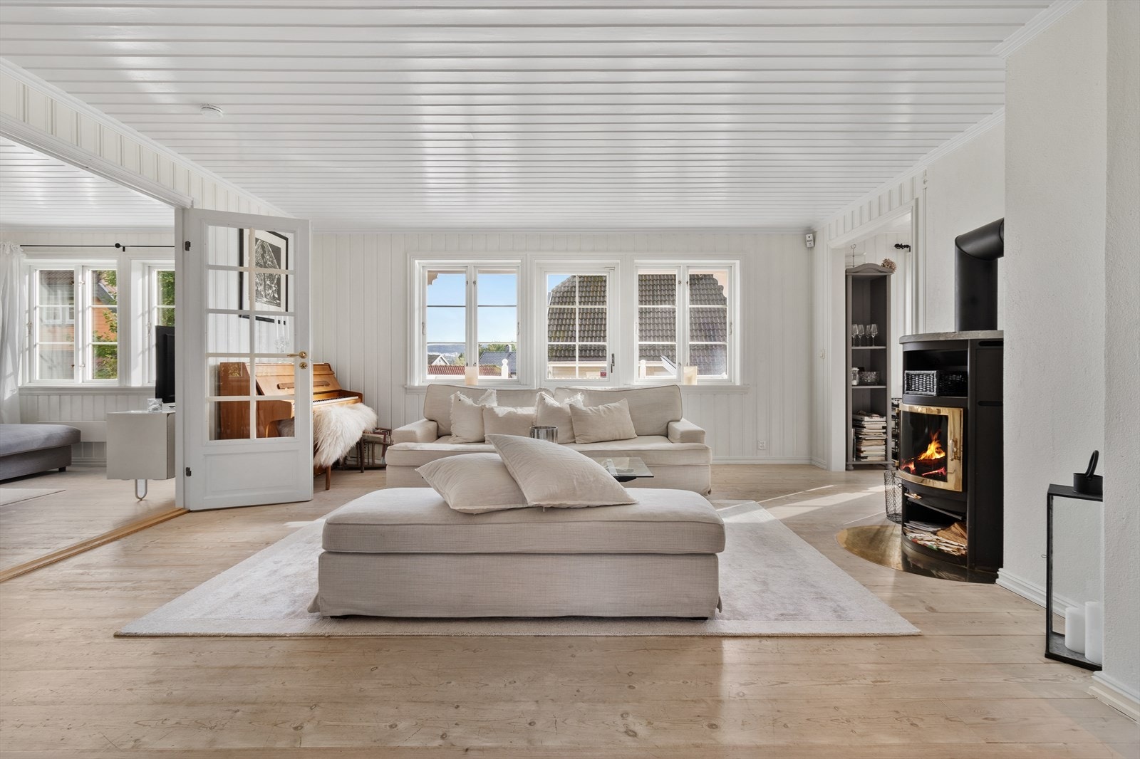 Stuen er lys og tiltalende med store vindusflater og moderne peisovn. Galleribilde