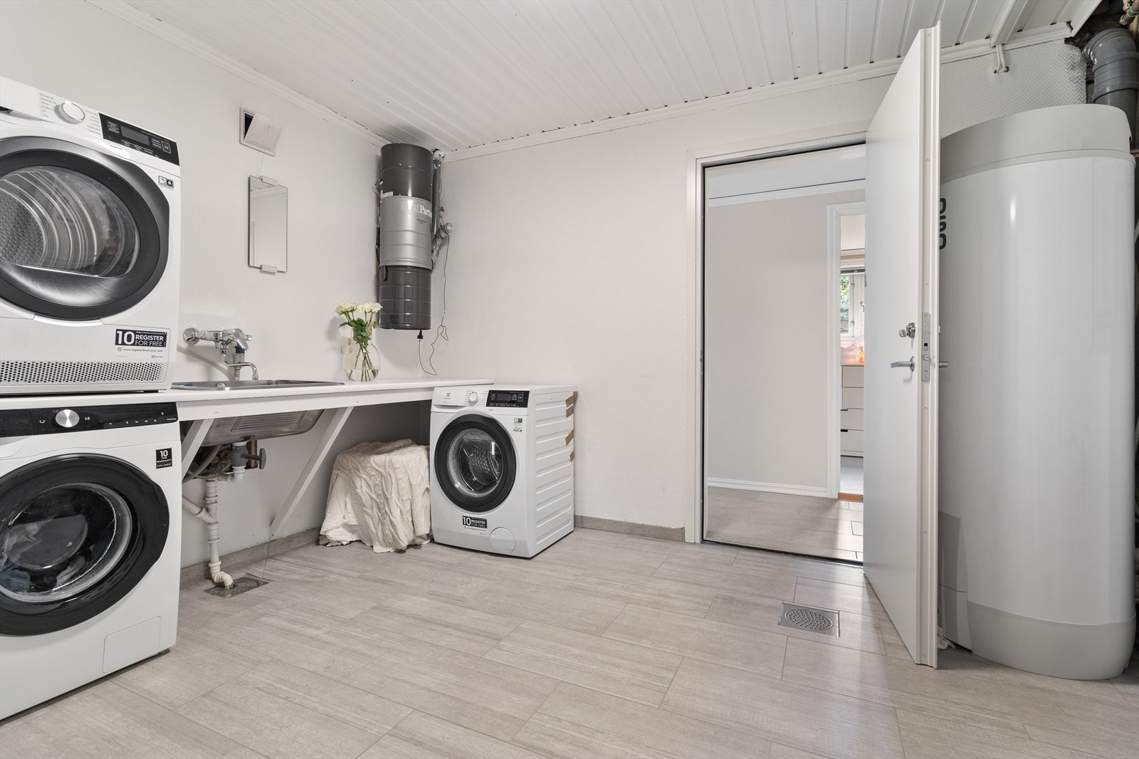 Stort vaskerom med praktiske løsninger og opplegg for både vaskemaskin og tørketrommel. Galleribilde