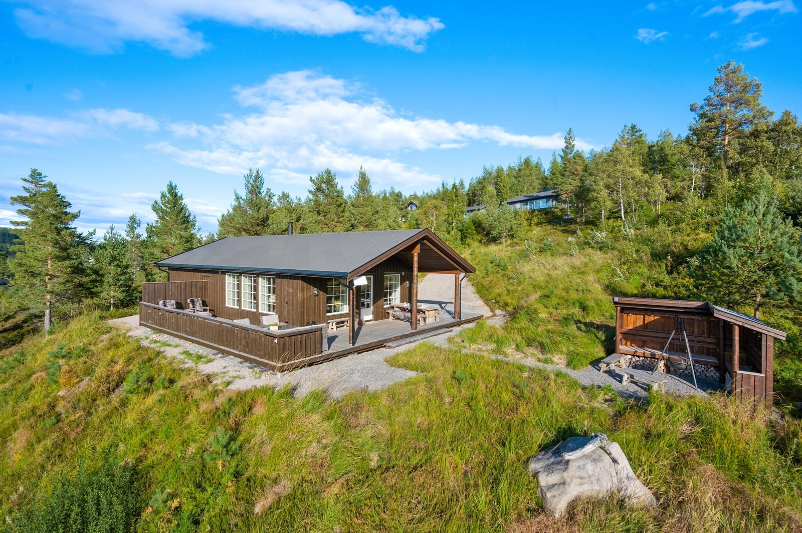 Tomten er stor og opparbeidet med blant annet bålplass med gapahauk, terrasse og avsatt område til Jacuzzi. Galleribilde