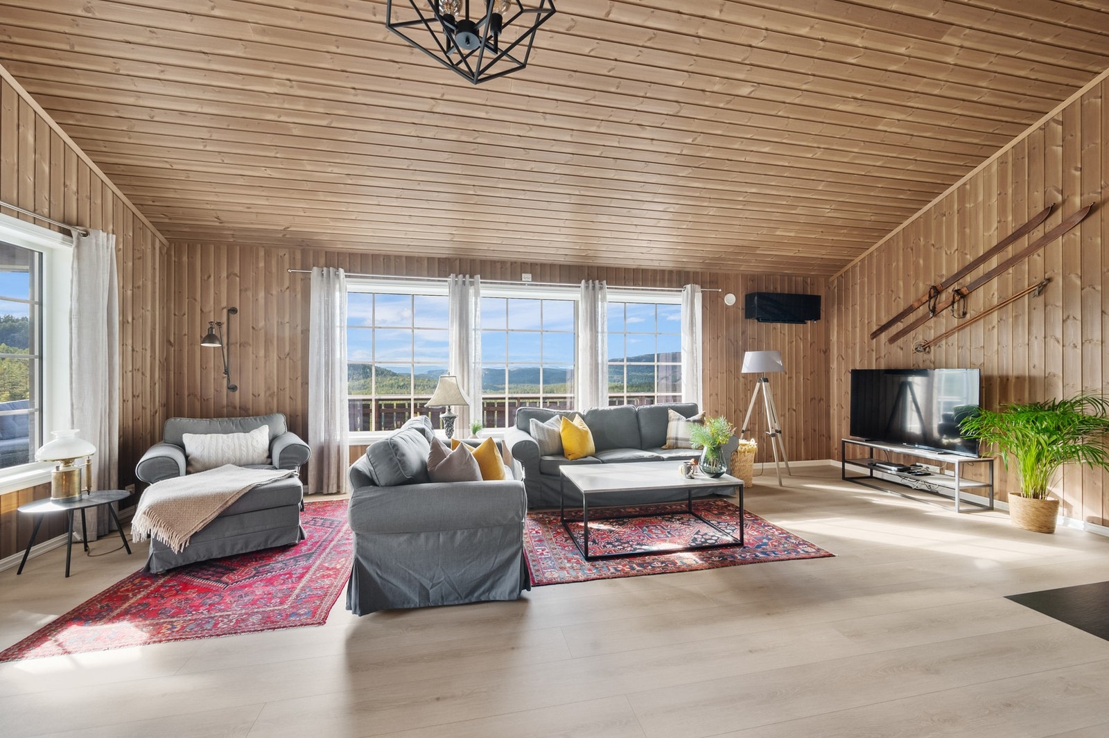 Lyst og luftig oppholdsrom med store vinduer og utsikt utover nærområdet. Galleribilde