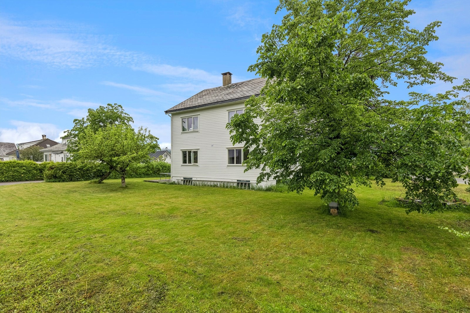 Eiendommen er opparbeidet med stor plen og diverse busker og trær. Galleribilde