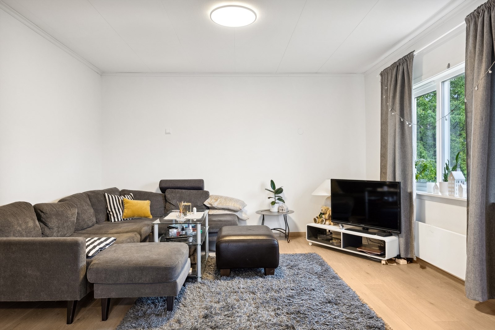 Stuen har god plass til sofagruppe og underholdningssone. Store vinduer gir rikelig med naturlig lys og fin utsikt mot grønne omgivelser. Galleribilde