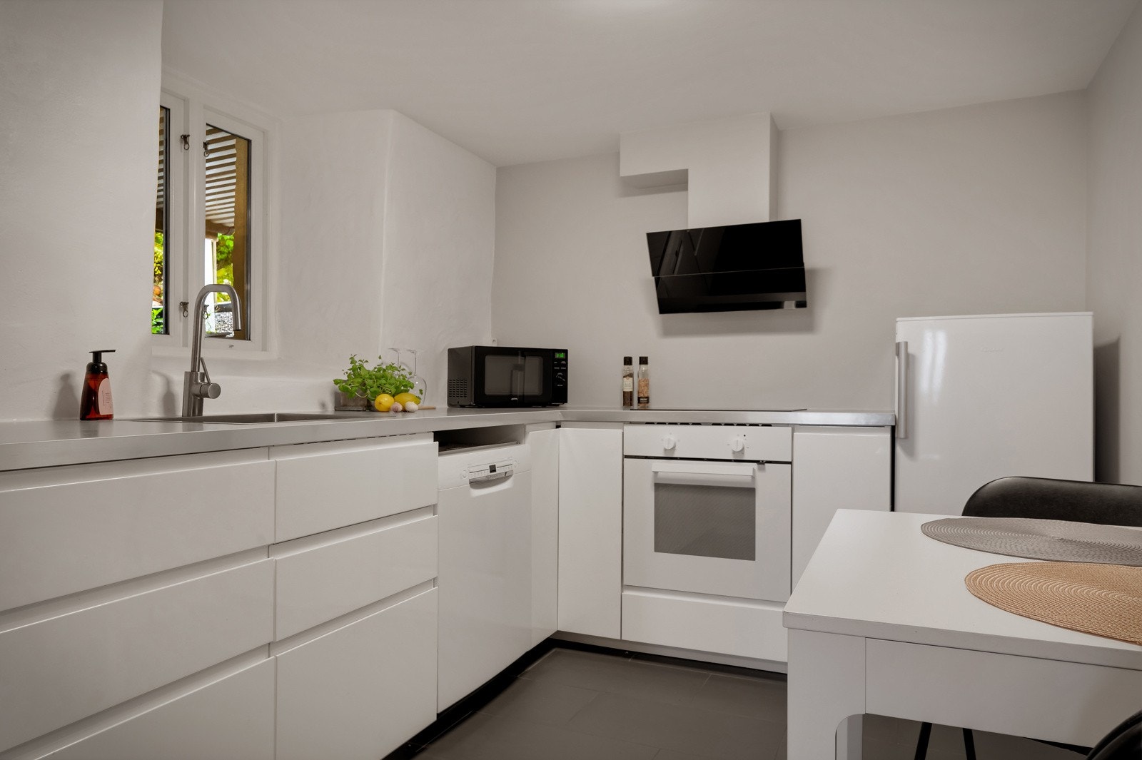 Kjøkken fra 2019 med slette fronter med integrerte håndtak. Laminat benkeplate med nedfelt stål vaskebeslag. Galleribilde