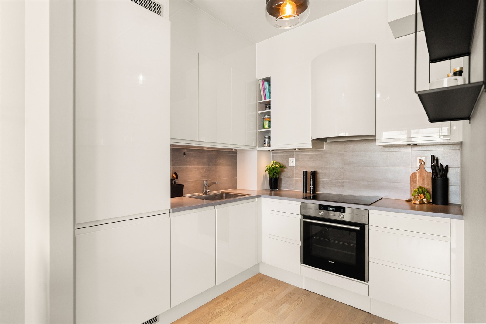 Praktisk kjøkkeninnredning fra Sigdal med integrert koketopp med induksjon, stekeovn, oppvaskmaskin og kjøl/frys Galleribilde