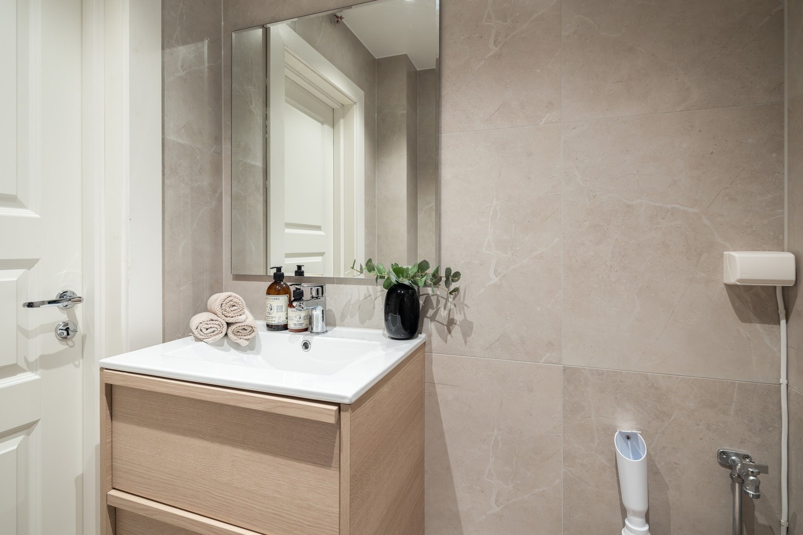 Eksklusiv innredning med finér eikefronter og delikate fliser. Det er opplegg for vaskemaskin på badet. Galleribilde