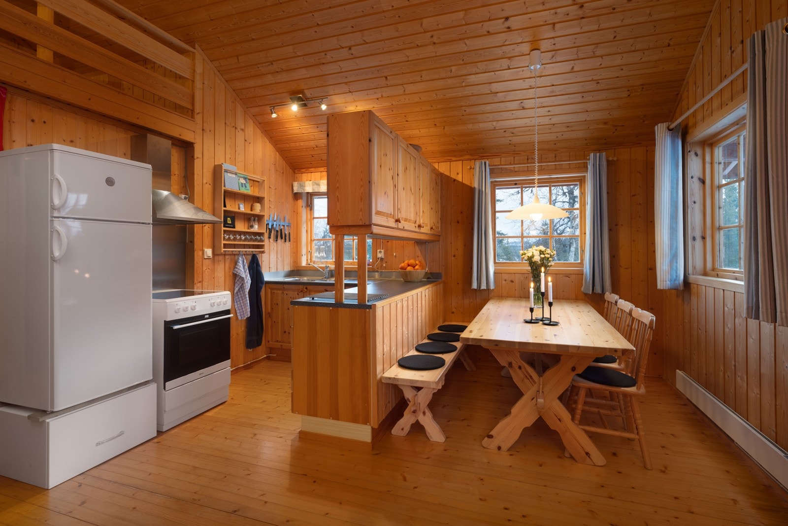 Hytten har en klassisk og solid kjøkkeninnredning i heltre furu, med lakkerte profilerte fronter og benkeplater i laminat. Galleribilde