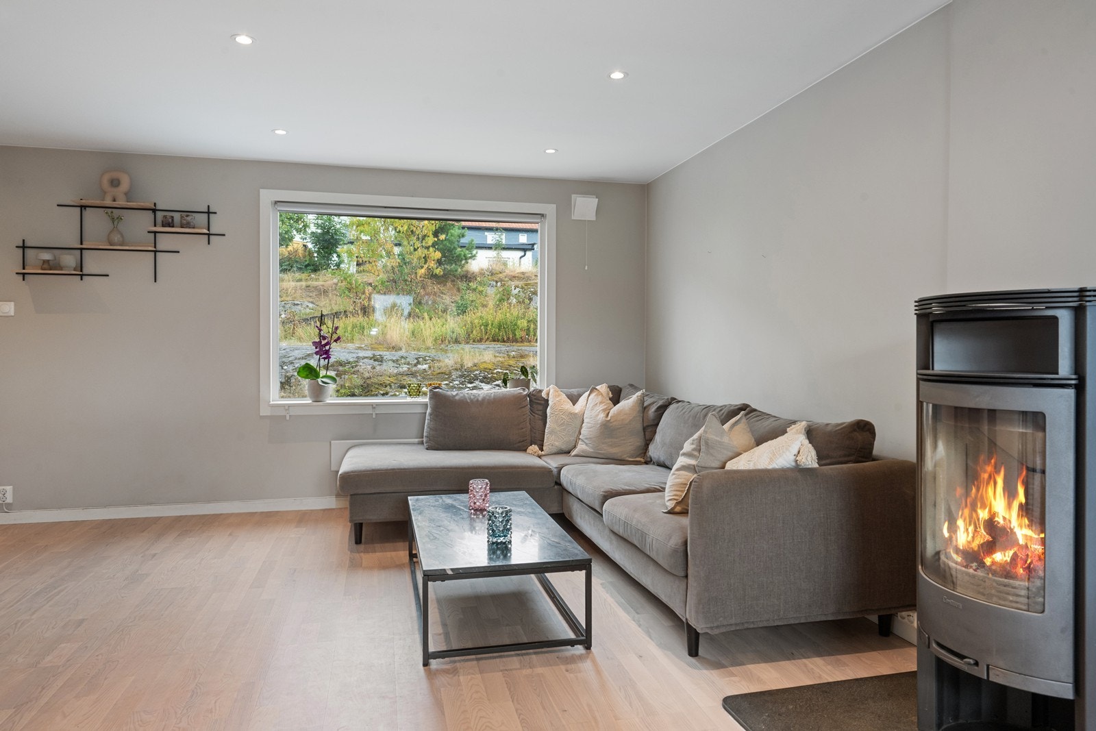 Store vindusflater gir rom for både dagslys og utsikt til uteområdet fra stuen. Galleribilde