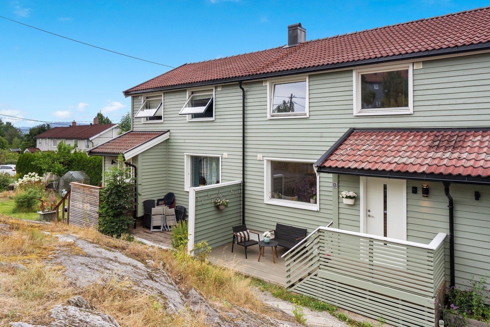 Sjarmerende fasade med gjennomgående tregjerde og hyggelig inngangsparti til rekkehuset. Galleribilde