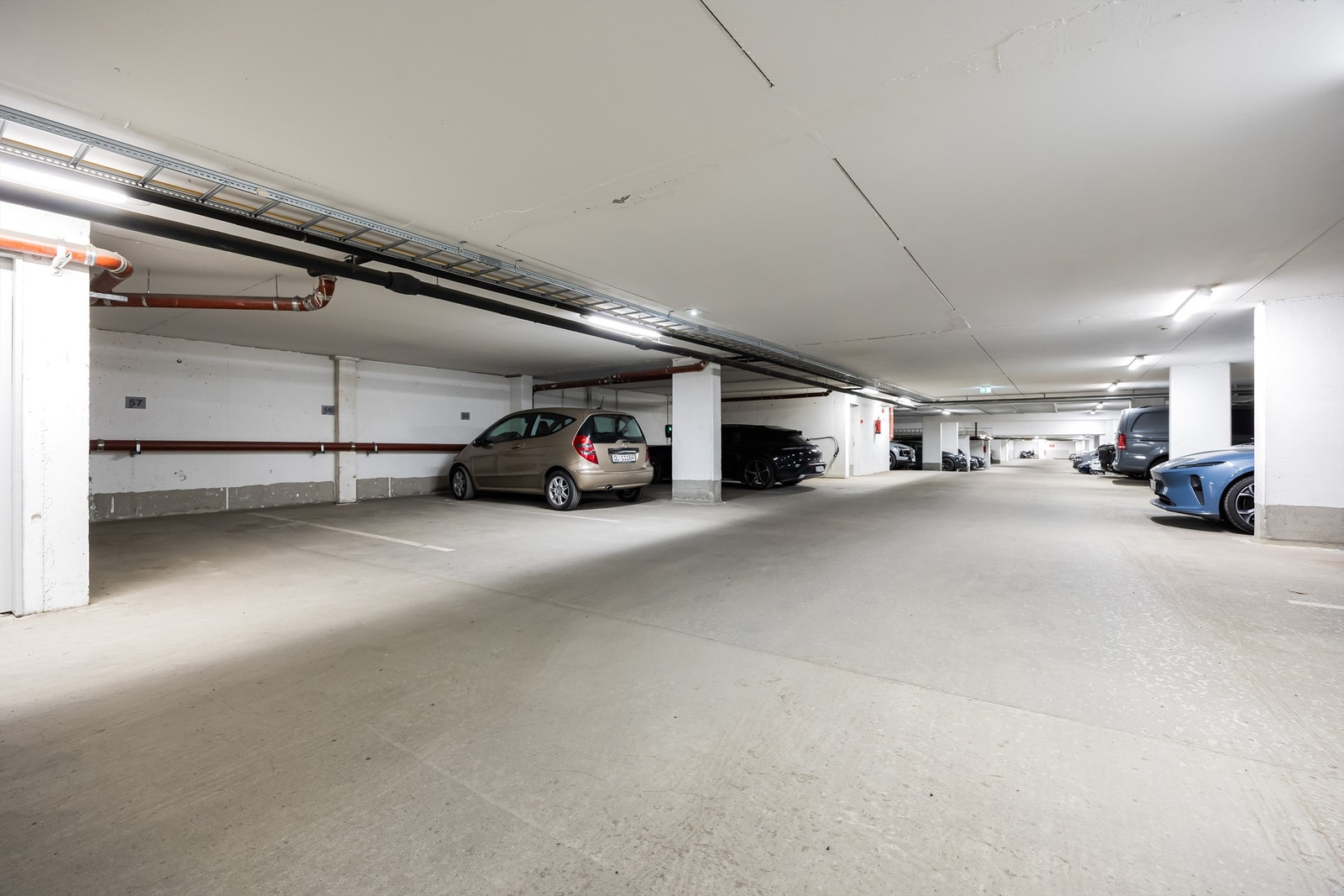 Det er oppvarmet garasjeanlegg i kjeller hvor det tidvis er mulig å leie eller kjøpe parkeringsplass. Galleribilde