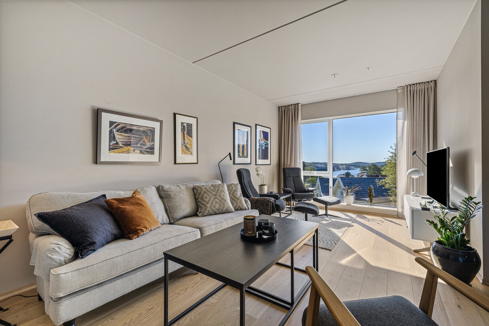 Fra tv-stuen er det stor og åpen utsikt mot vannet Galleribilde