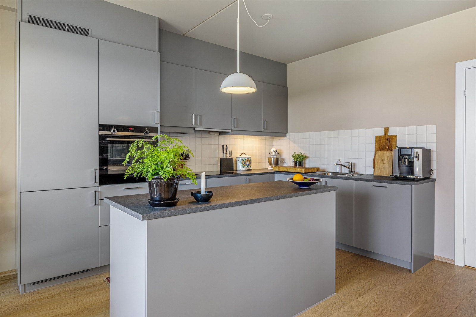 lekkert kjøkken med glatte fronter og benkeplate av laminat Galleribilde