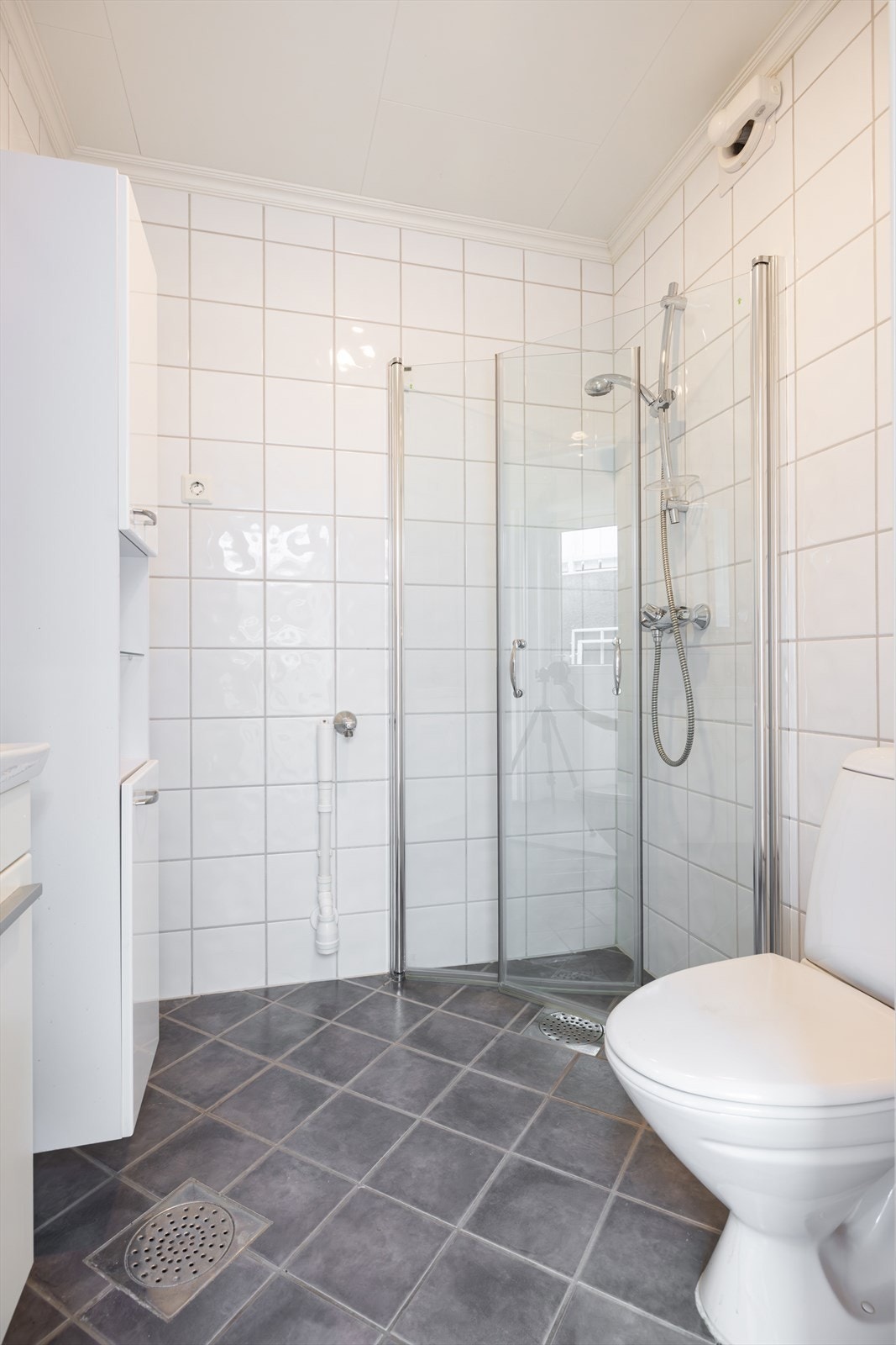 Pent flislagt baderom med dusjsone og opplegg for vaskemaskin i underetasje. Det er vannrør i tilknytning vegg mot stue i underetasje Galleribilde