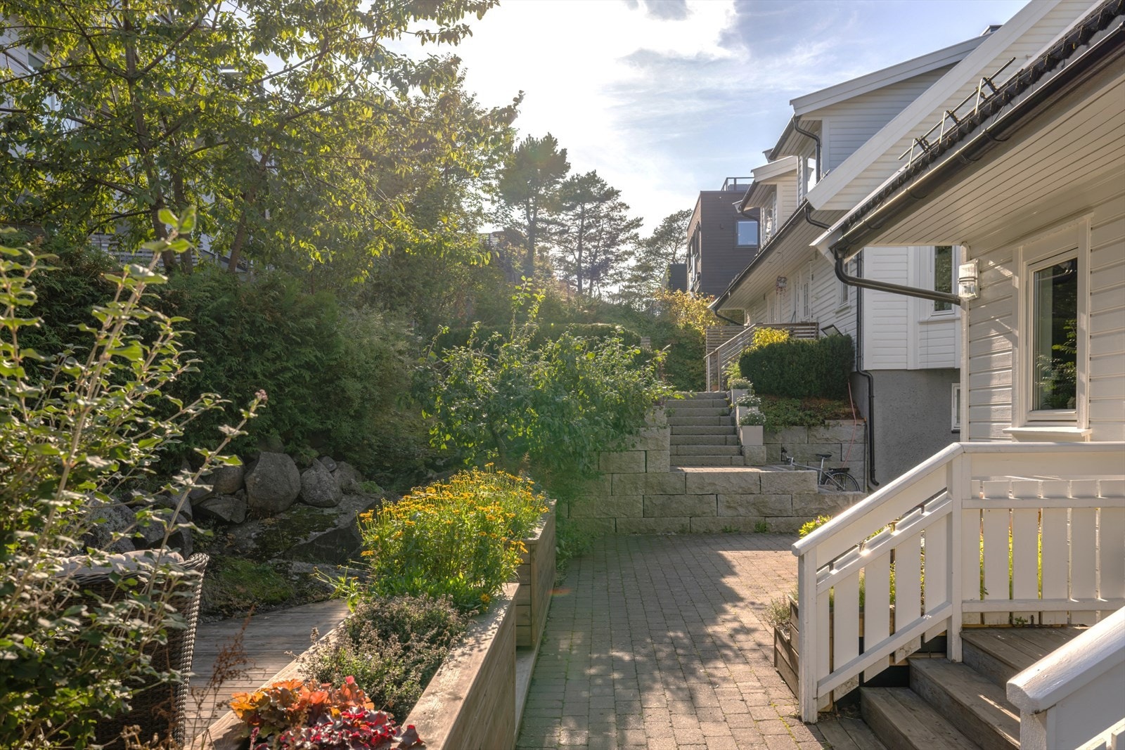 Enkel adkomst til boligen med brosteinsbelagt oppgang. Platting og blomsterkasser 2020 Galleribilde