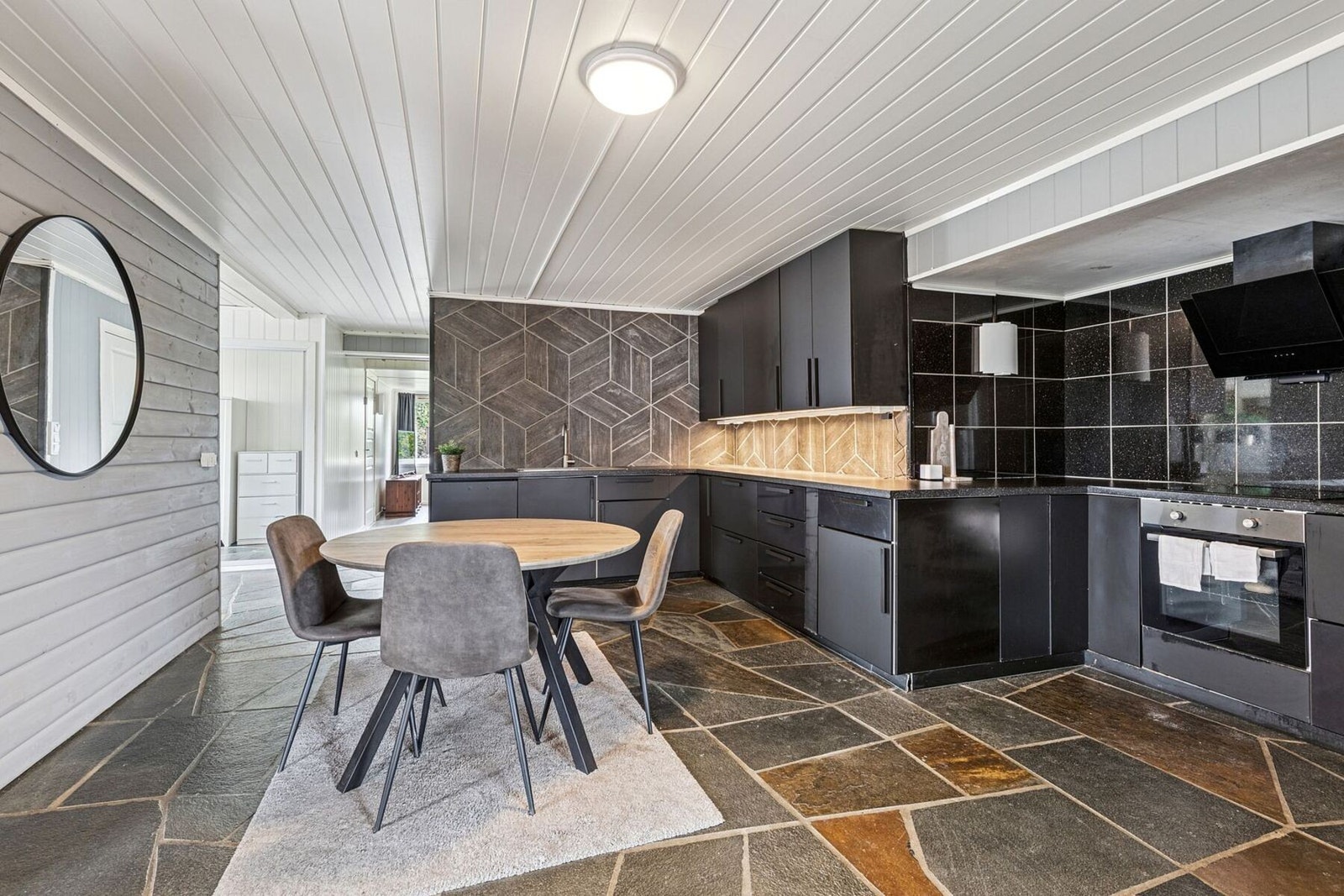 Kjøkkenet er moderne og stilrent, med mørke slette fronter som gir et tidløst uttrykk. Galleribilde