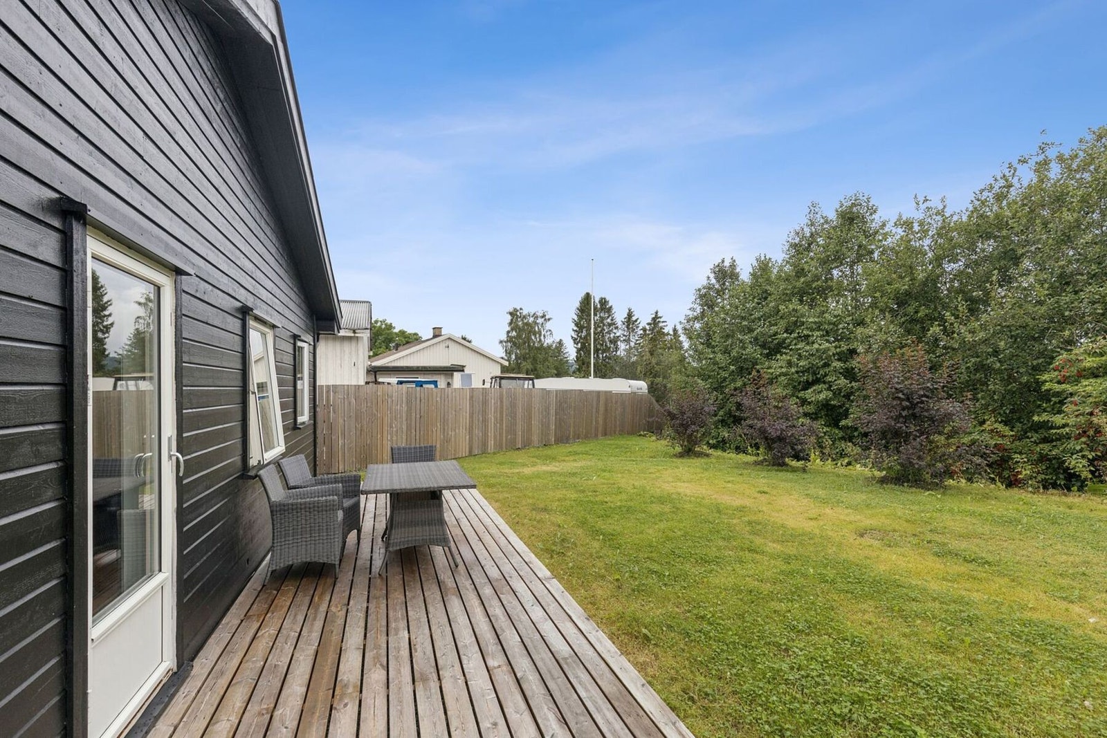 Ute byr eiendommen på en solrik tomt med hage og terrasseplatting. Perfekt for å skape din egen drømmeoase! Galleribilde