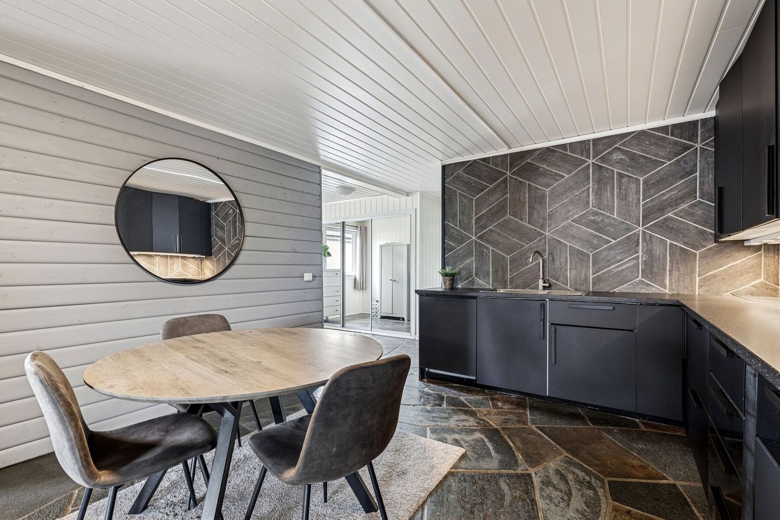 Den praktiske løsningen byr på rikelig med skap- og benkeplass, og de integrerte hvitevarene gjør hverdagen enkel og funksjonell. Galleribilde