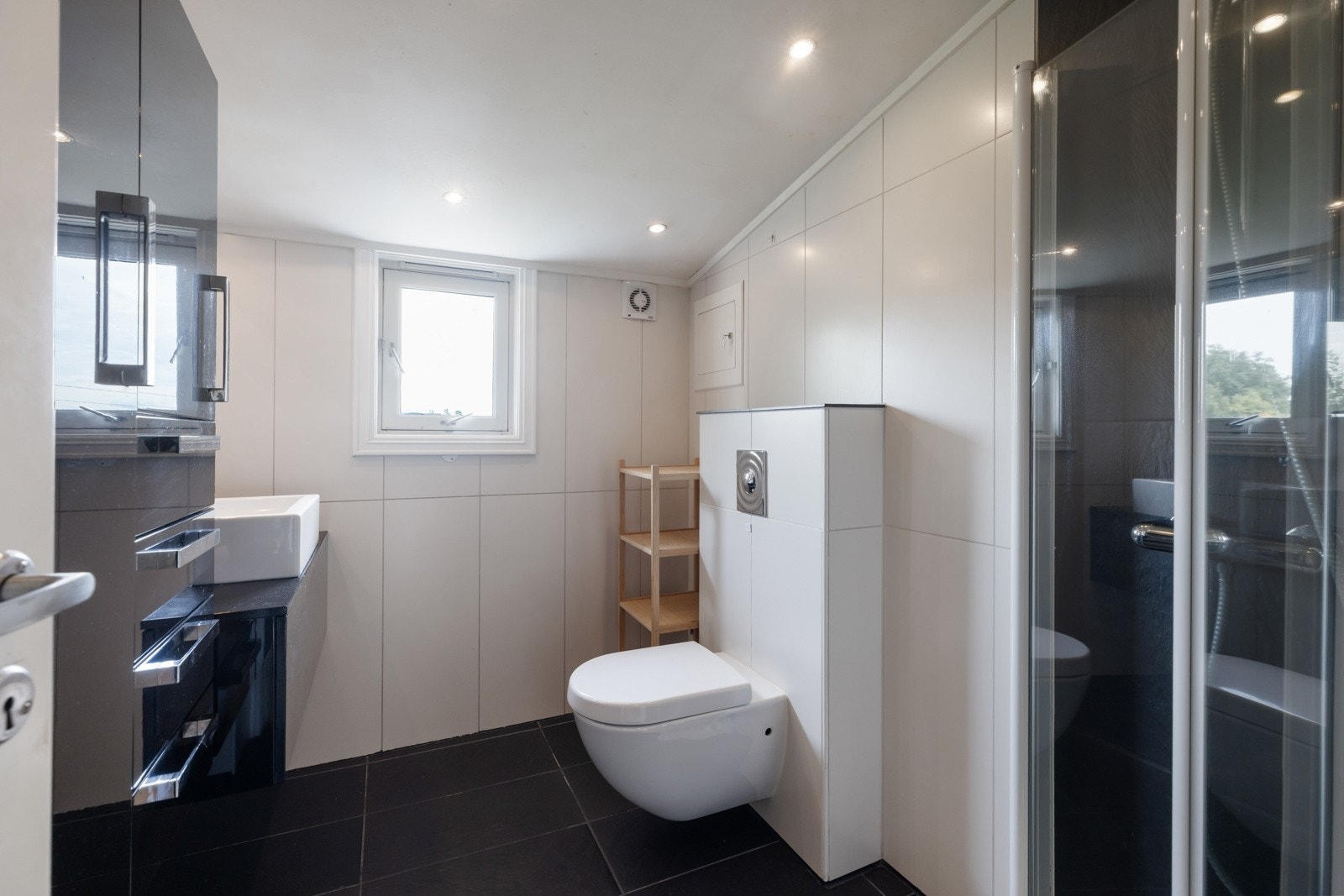Badet har veggmontert WC og praktisk innredning med godt med lagringsplass. Galleribilde