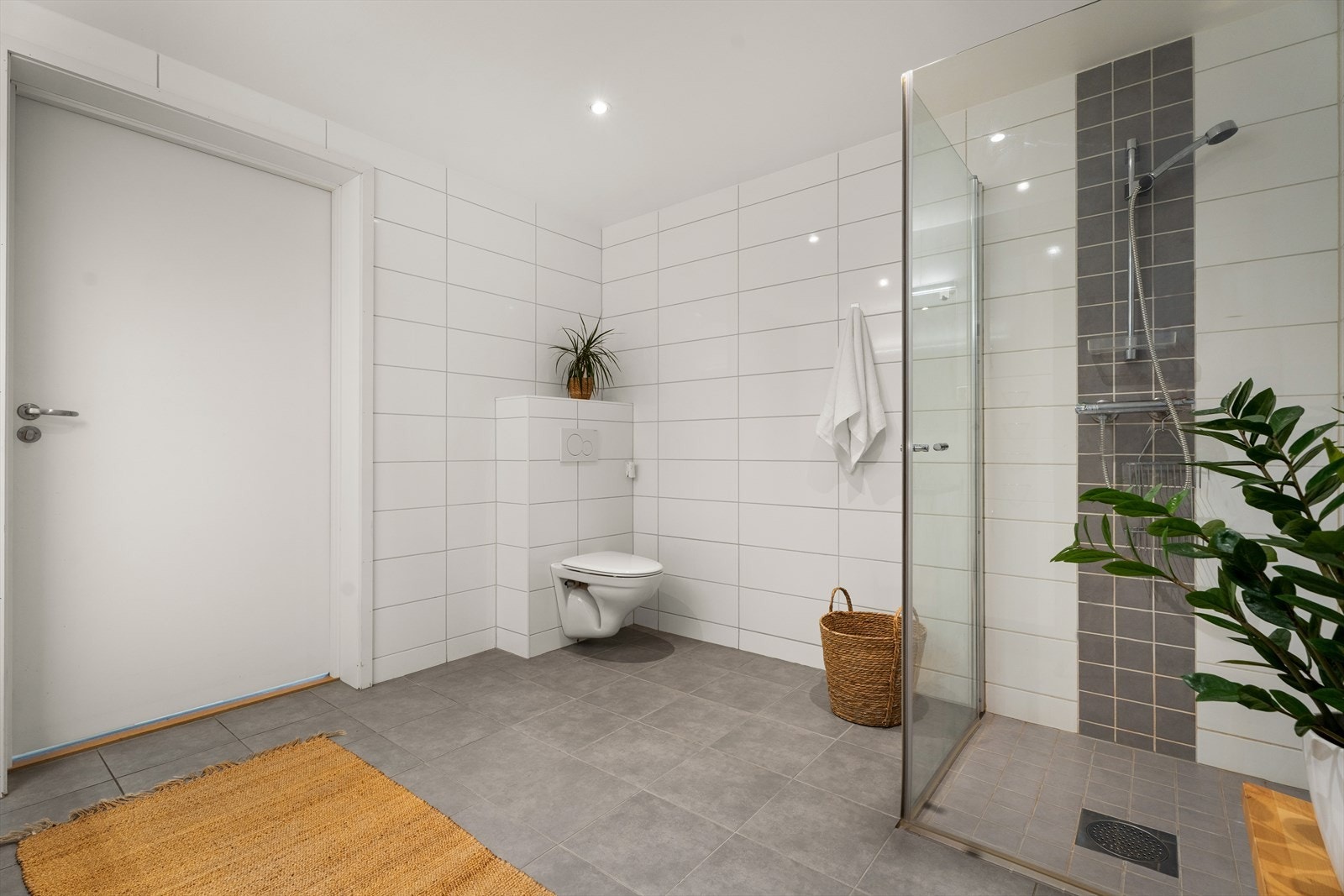 Baderommet har dusjhjørne med innfellbare glassdører og vegghengt toalett. Avtrekk via balansert ventilasjon. Galleribilde