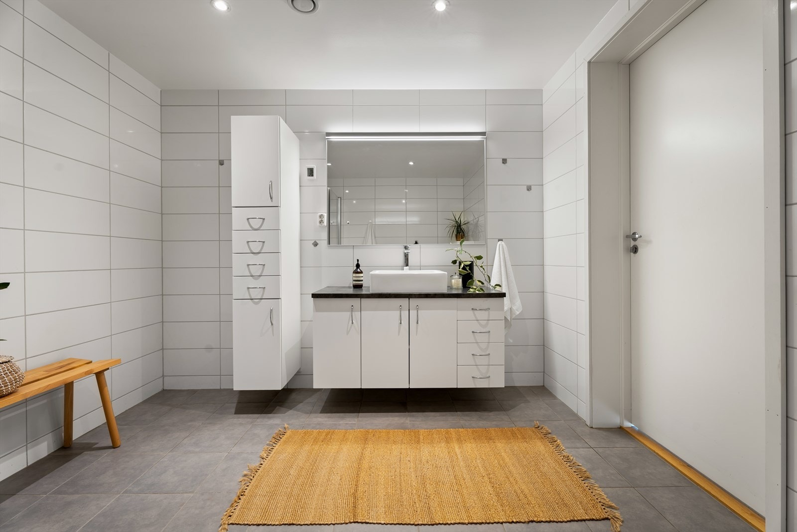 Badet er utstyrt med pen servantinnredning med lyssatt speil over samt oppbevaringsskap. Galleribilde