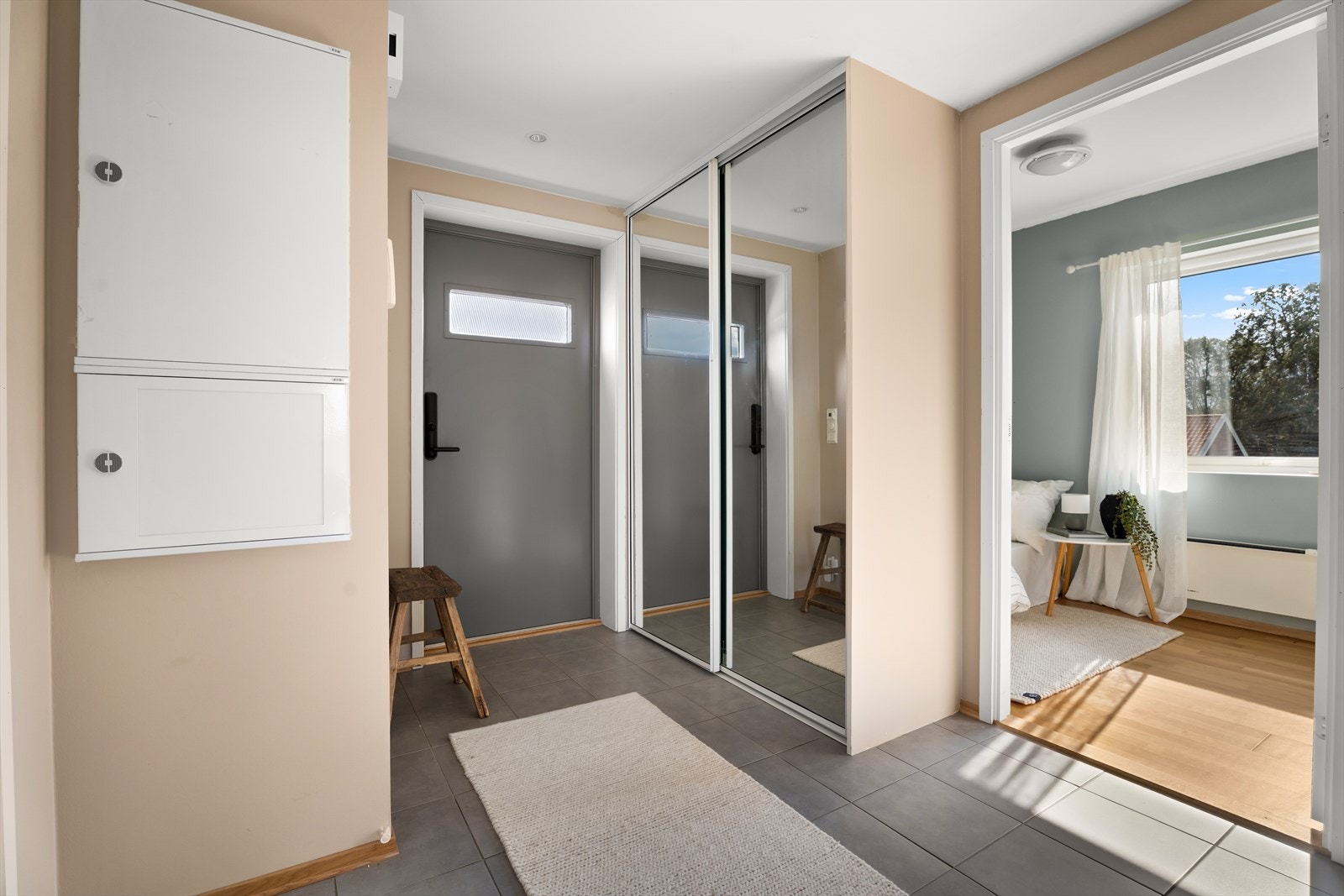 Entréen har flislagt gulv og skyvedørsgarderobe med glassfronter. Galleribilde