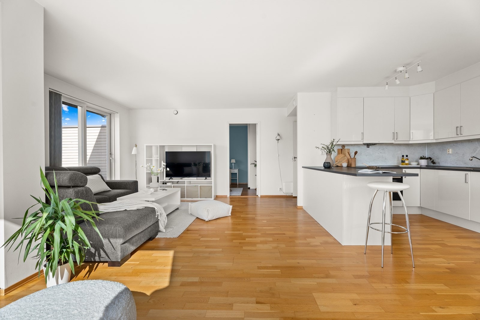 Kjøkkenet har en lekker- og tidløs kjøkkeninnredning med hvite slette fronter, laminert benkeplate og oppvaskkum. Galleribilde