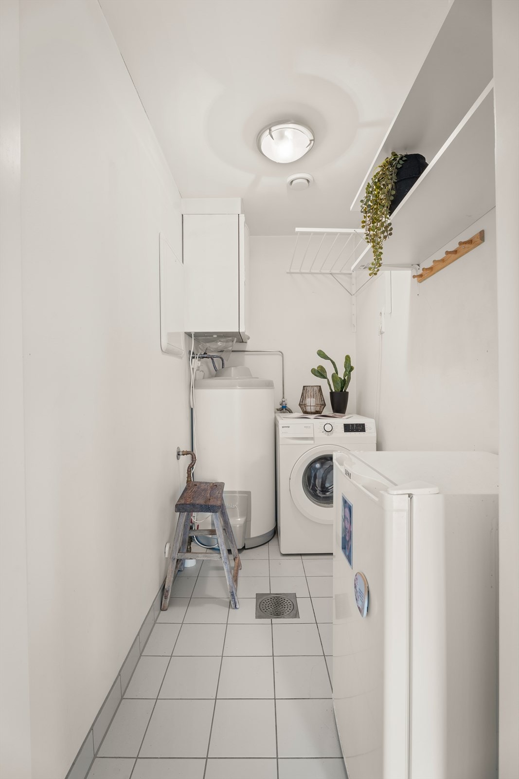 Bod/teknisk rom/vaskerom med fliser på gulv og malt gips i tak og vegger. Vaskerommet har opplegg for vaskemaskin, varmtvannsbereder og aggregat for balansert ventilasjon. Galleribilde