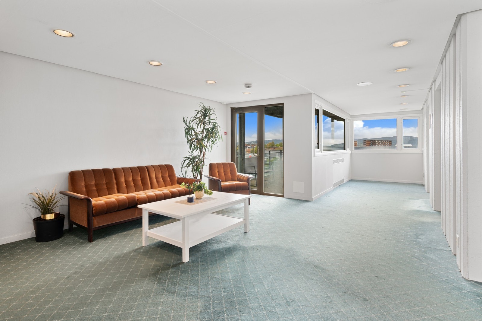 Fellesareal i gang med sitteplasser - Heis i bygget. Galleribilde