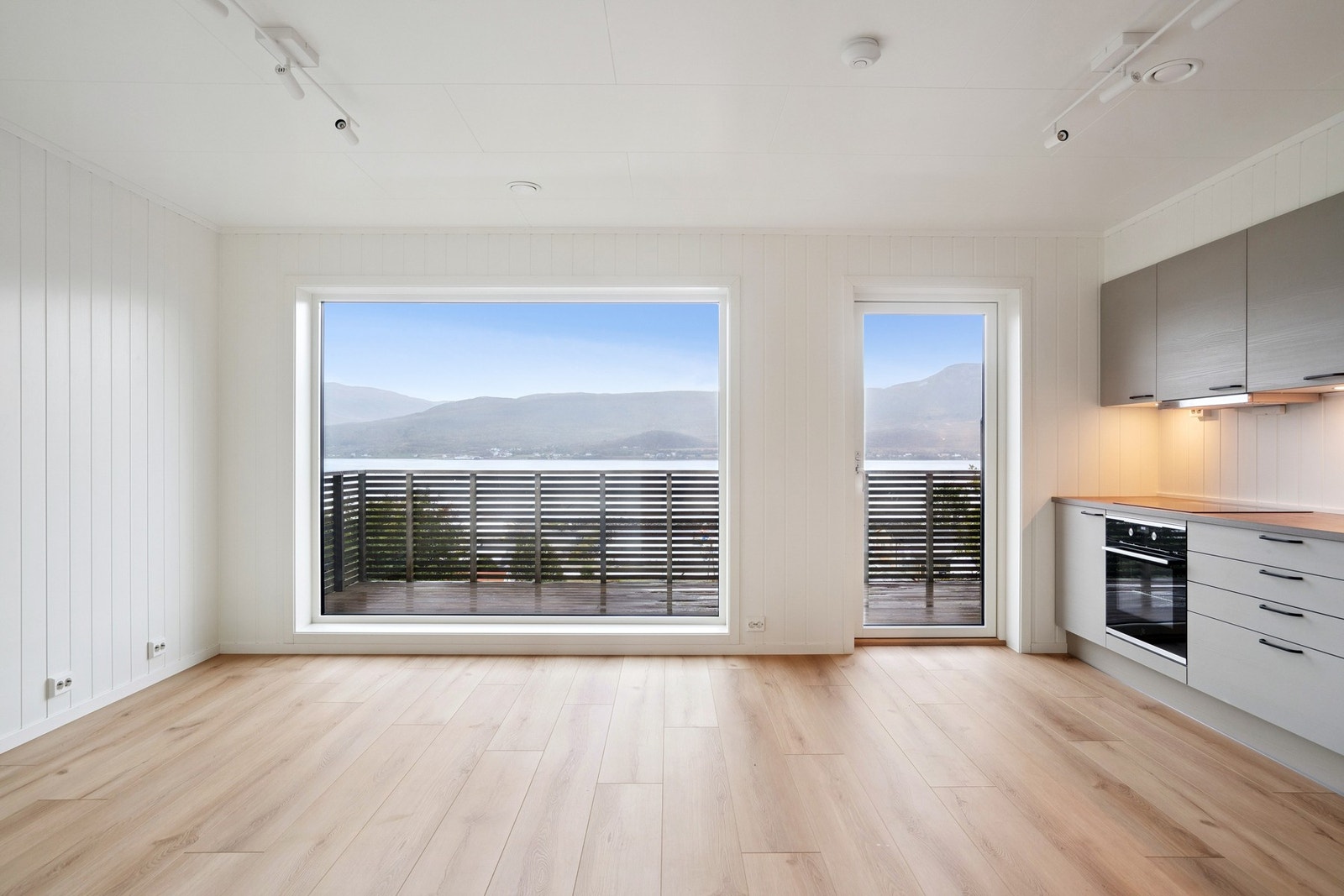 Stue med balkong og store vinduer i front. Galleribilde