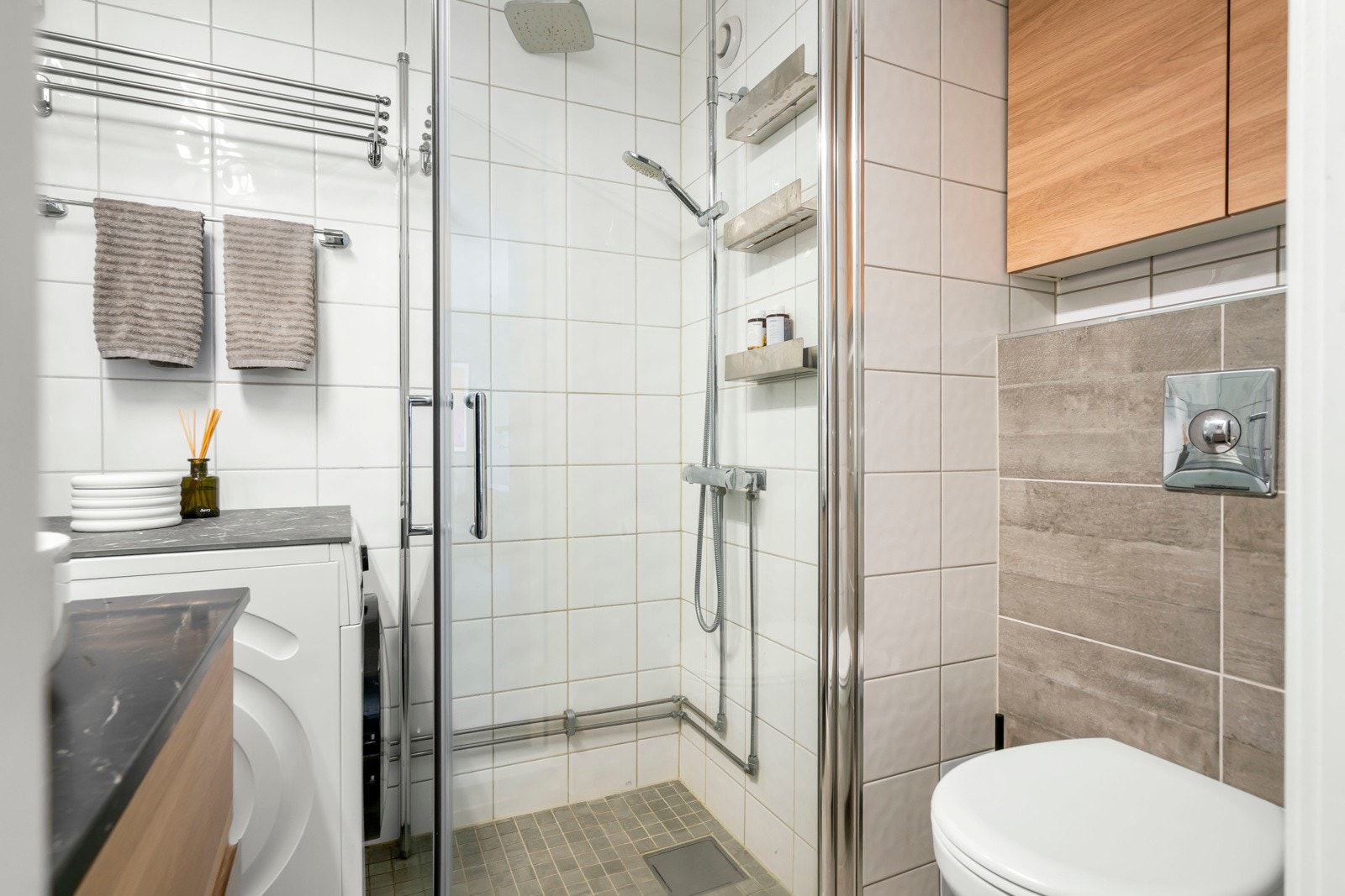 Badet byr på servantskap med profilerte fronter og heldekkende servant, speilskap med lysarmatur på vegg over servant og toalett. Galleribilde