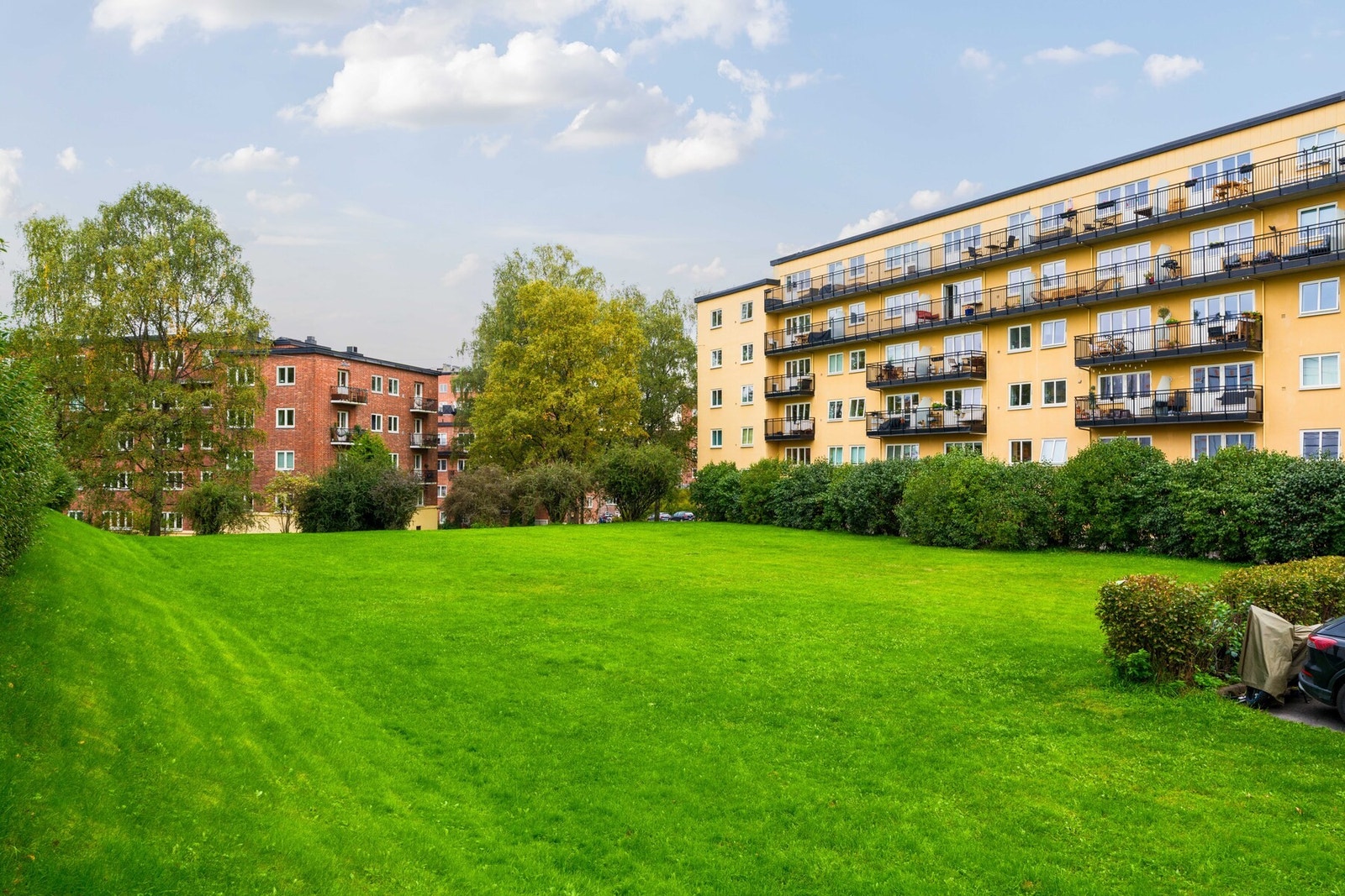 Området utenfor blokken er en kommunal tomt som er regulert til friområde. Gressplenen benyttes hovedsakelig av beboerne til soling, opphold og god stemning. Galleribilde