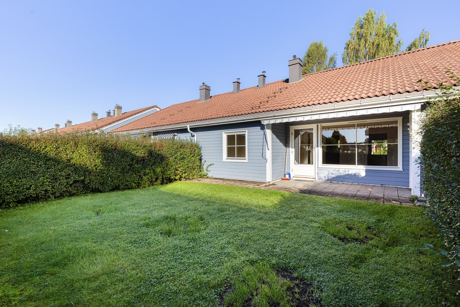 Ut fra stua er det etablert en fin uteplass med betongheller som er delvis overbygget. Galleribilde