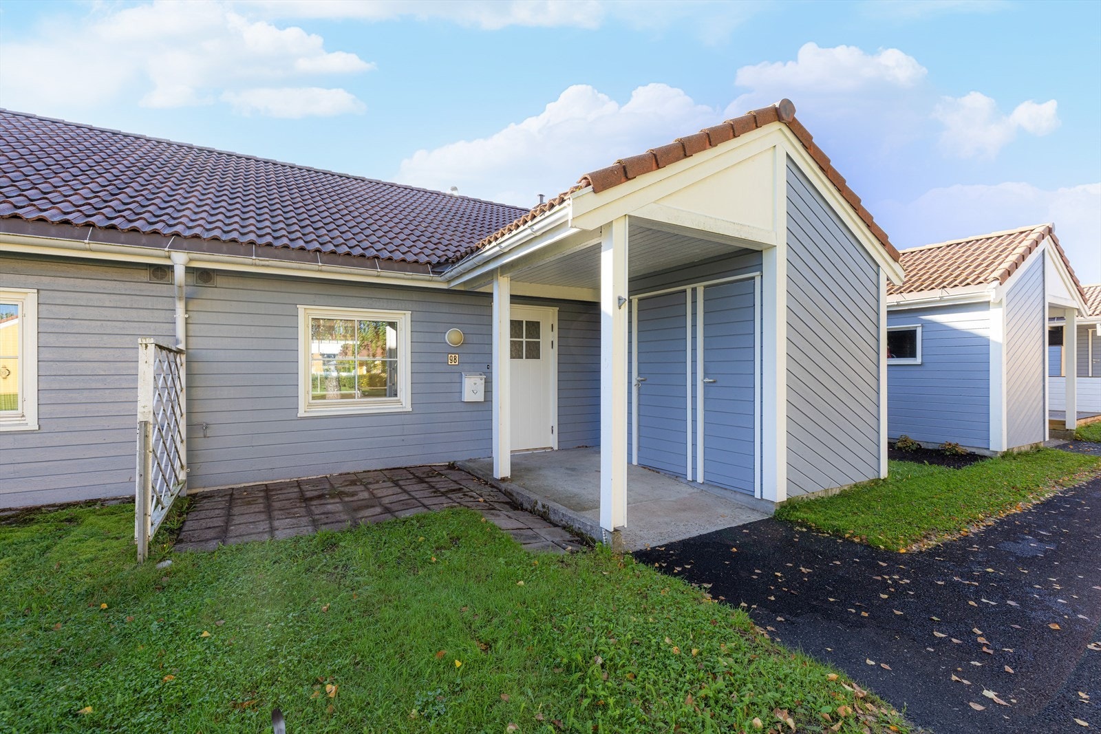 Hyggelig inngangsparti med hellelagt uteplass og boder Galleribilde