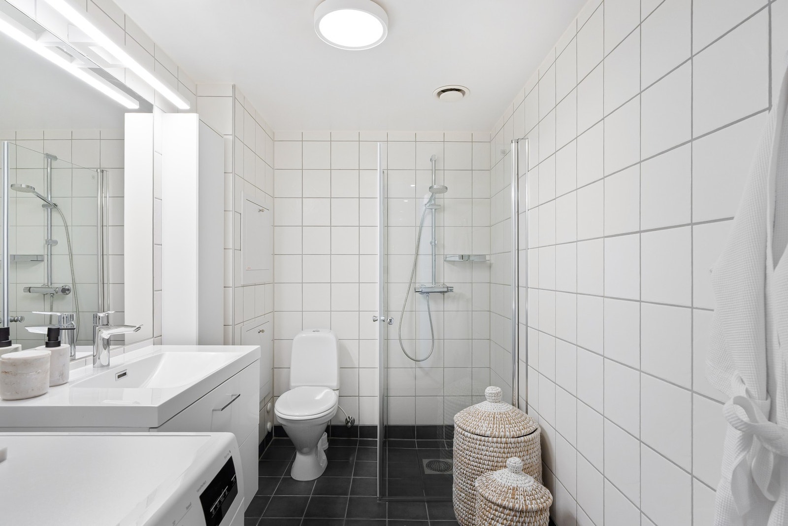 Flislagt baderom med varme i gulv og opplegg for vaskemaskin. Galleribilde