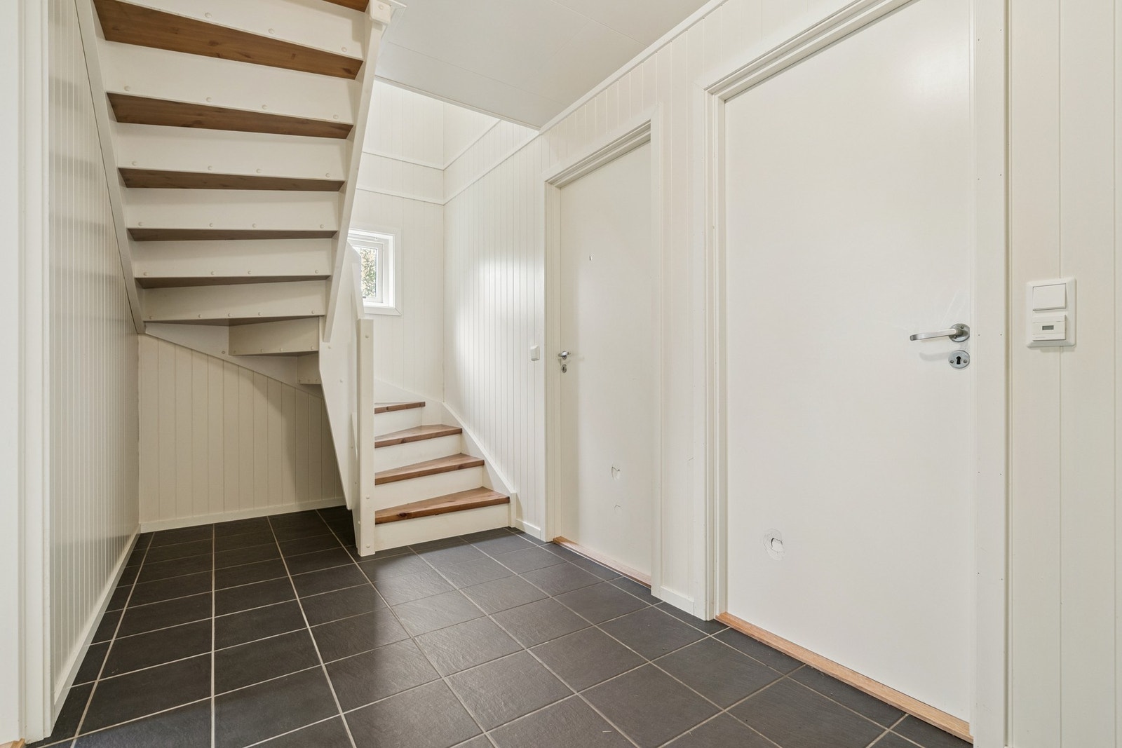 Velkommen inn! Boligen entres i første etasje, i en praktisk entré, med adkomst til en større gang med trapp. Her får man plass for ulik oppbevaring av yttertøy. Galleribilde
