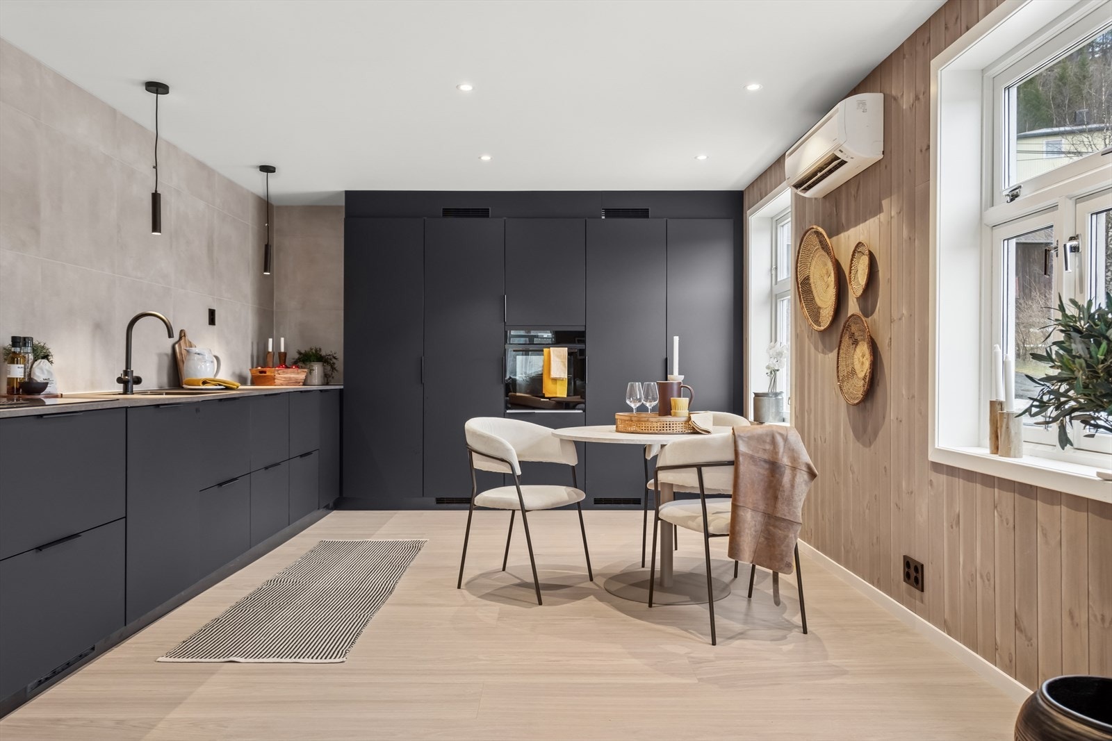 Videre inn i 1. etasje finner du kjøkkenet, som ble pusset opp i 2024. På langsiden er det rikelig med oppbevaringsplass i skuffer og på benken, mens på kortsiden finner du en praktisk skapløsning i takhøy utførelse. Galleribilde