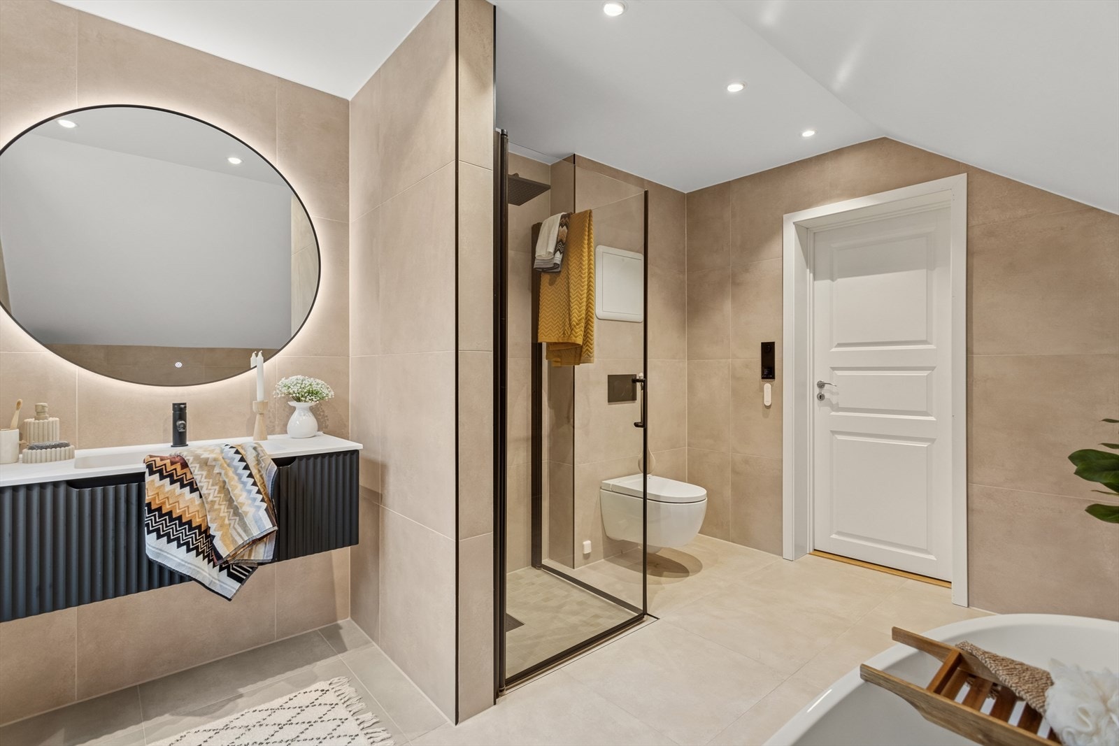 Downlights i himling og 60x60 fliser på vegg og gulv, fullfører det stilrene uttrykket. Her er det også badekar, ypperlig etter en lang arbeidsdag eller om du vil slappe av og trekke deg tilbake. Galleribilde