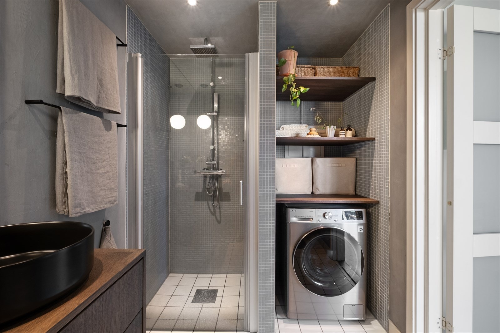 Badet innredet med toalett, dusjnisje med svingbare glassdører og opplegg for vaskemaskin. Galleribilde