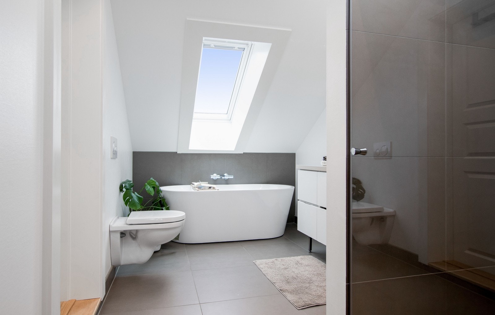 Delikat baderom med WC, servant m/innredning, badekar og regnfallsdusj. Galleribilde