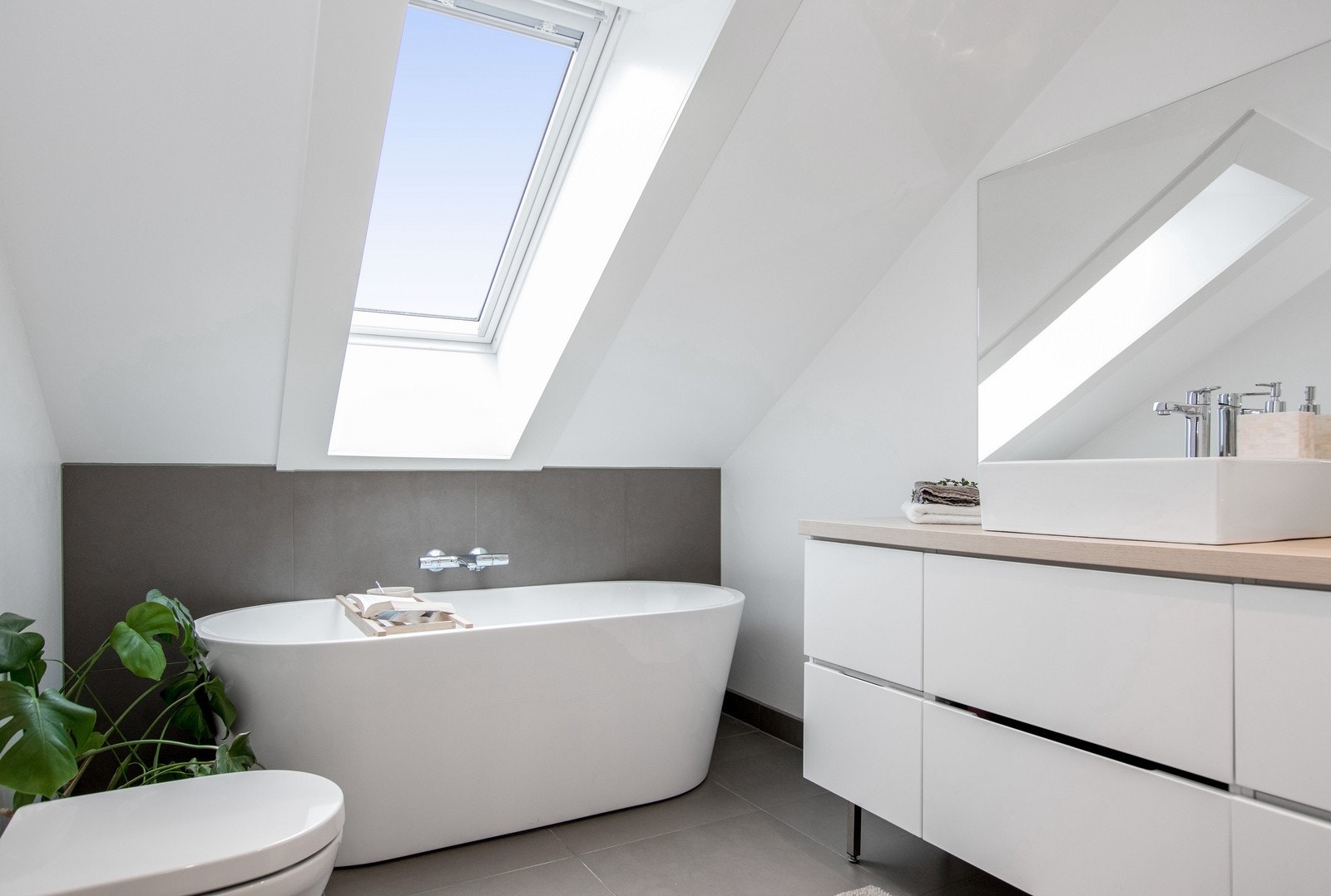 Delikat baderom med WC, servant m/innredning, badekar og regnfallsdusj. Galleribilde