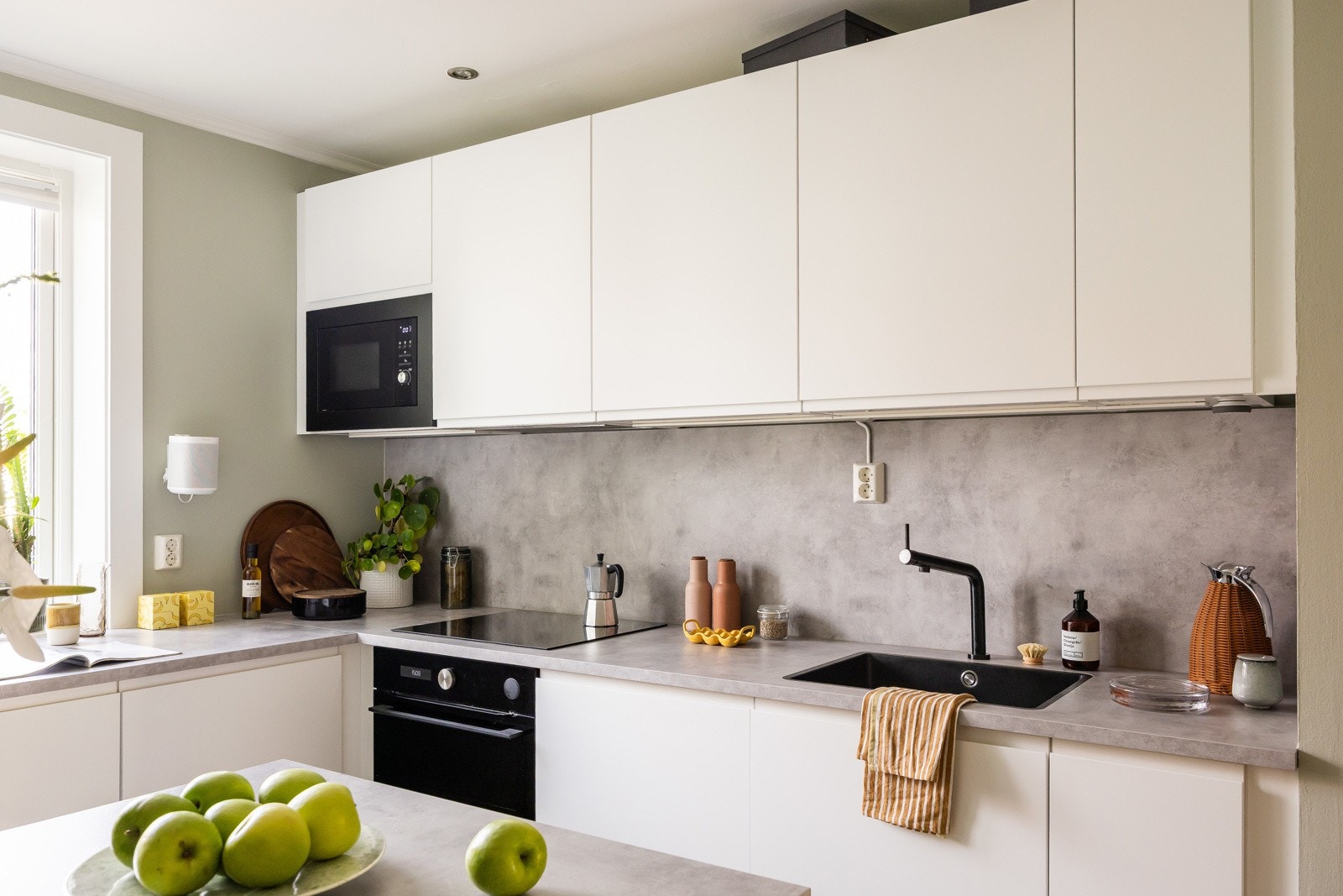 Innredning fra Ikea har god skap- og benkeplass med integrerte hvitevarer som oppvaskmaskin, stekeovn, koketopp, kjøl/frys og mikroovn. Galleribilde