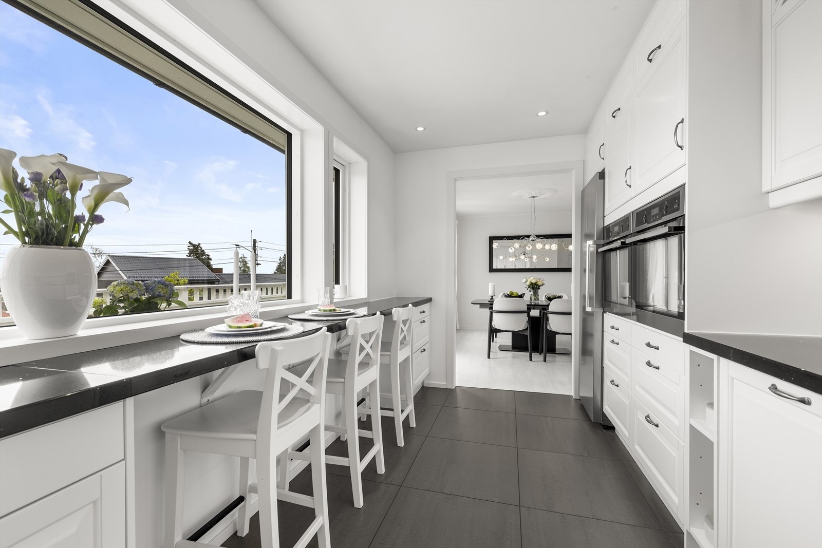 Integrerte hvitevarer som 80 cm koketopp, oppvaskmaskin med wi-fi og dobbel stekeovn. Frittstående kjøleskap, flislagt gulv med varmekabler og malte overflater. Galleribilde