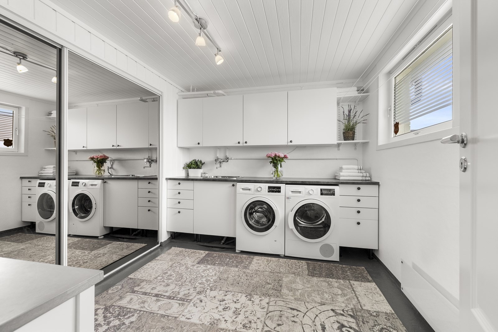 Stort vaskerom med praktisk garderobeløsning og oppbevaringsplass. Her er det opplegg for vaskemaskin og mulighet for tørketrommel. Galleribilde