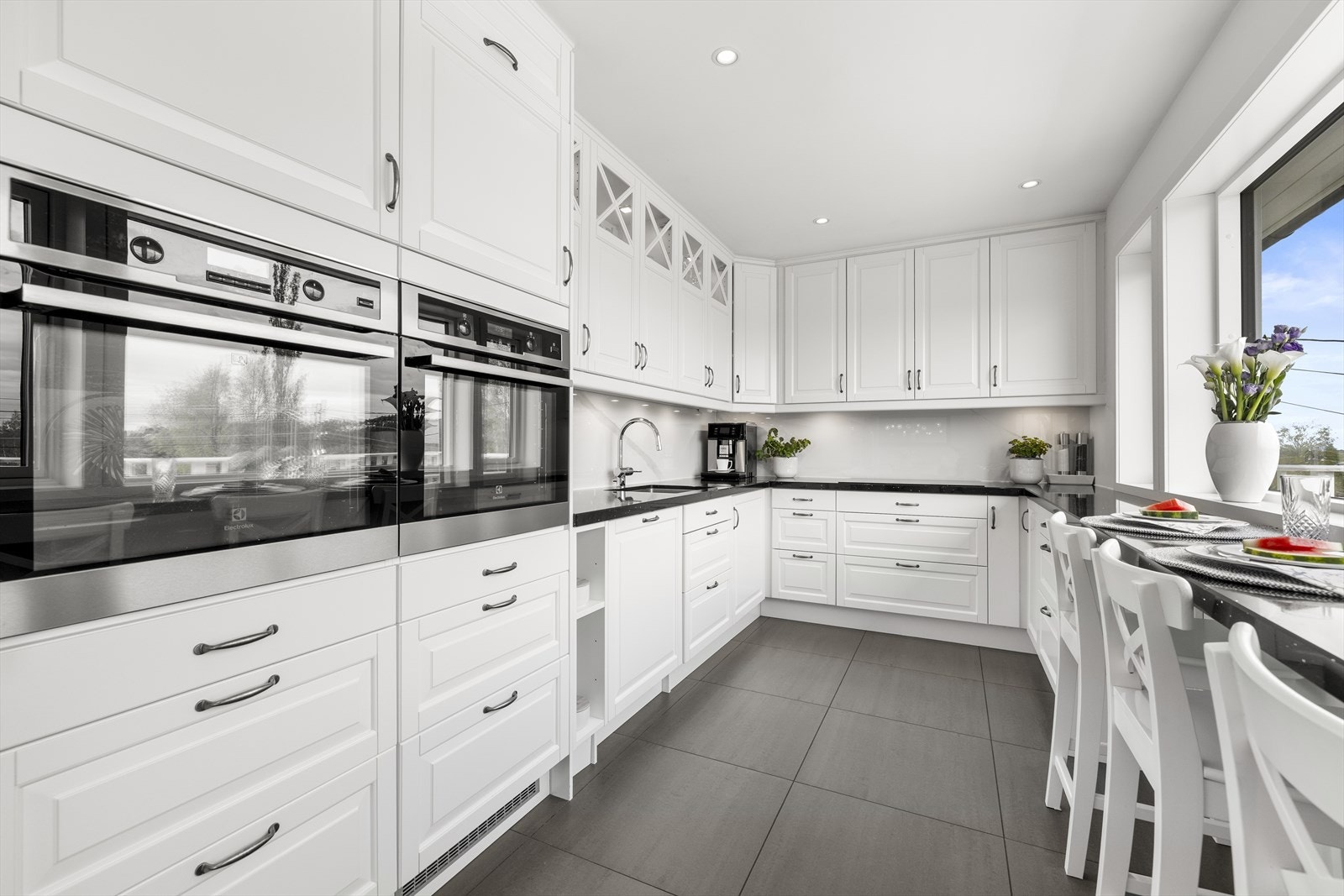 Innredningen består av hvite, profilerte fronter, benkeplate i stein og åpne hyller. Galleribilde