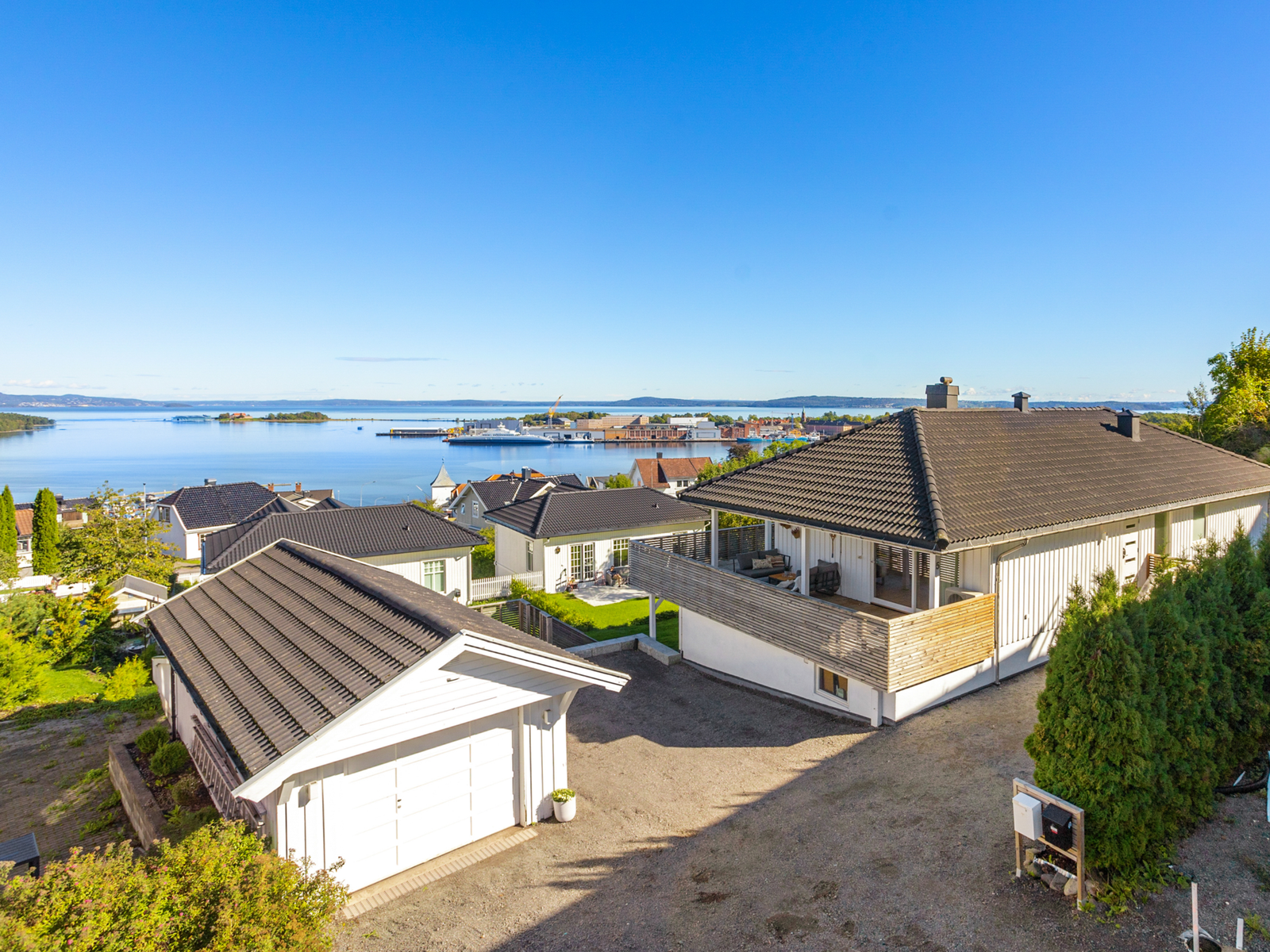 Frittliggende garasje og plass for parkering i gårdsplassen. Det er montert ladeboks på øst-side av garasje type Easee. Galleribilde